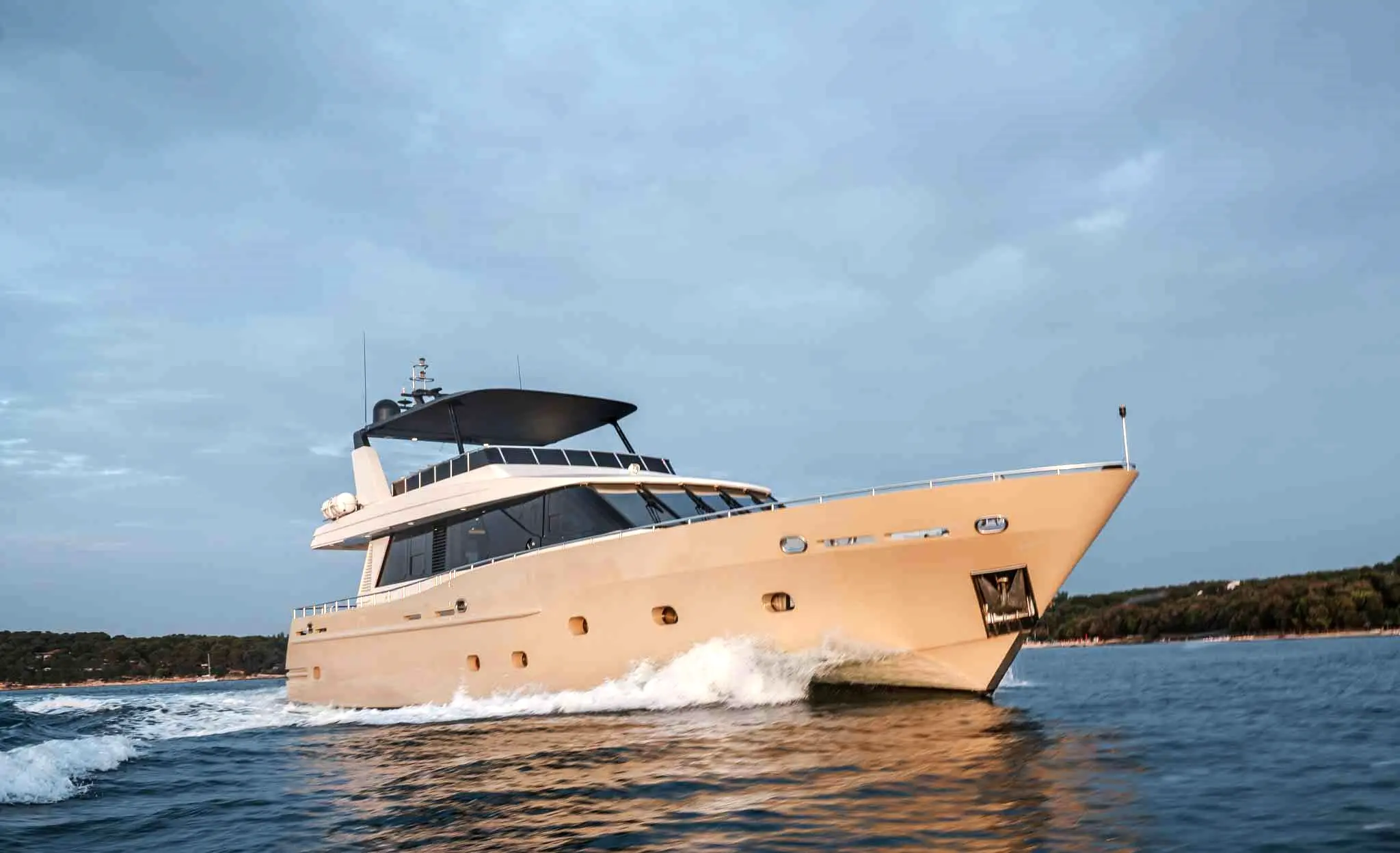 Oceanco 80 — Yacht à moteur photographié en navigation le long d'une côte boisée.