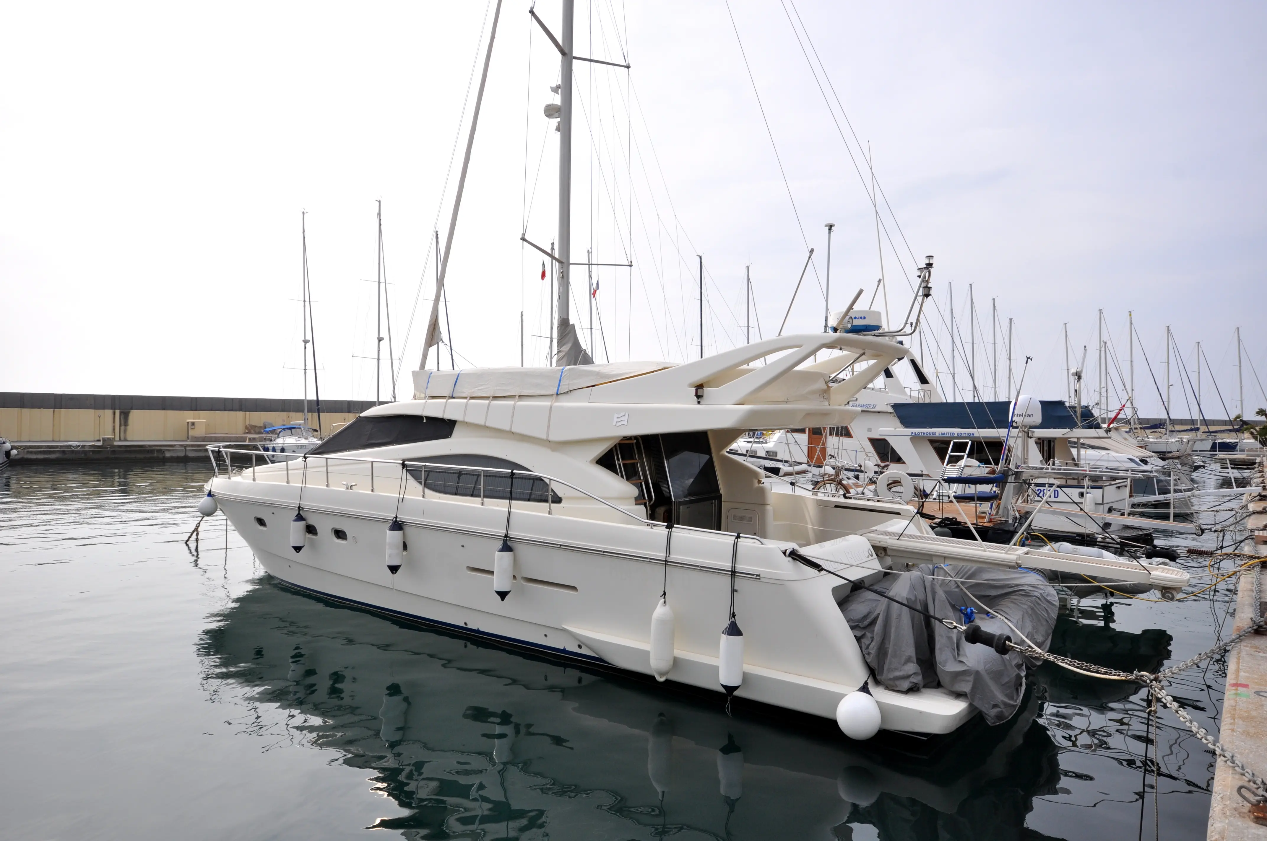 Ferretti 53 — Bateau à moteur blanc amarré dans une marina, vu de trois quarts bâbord.