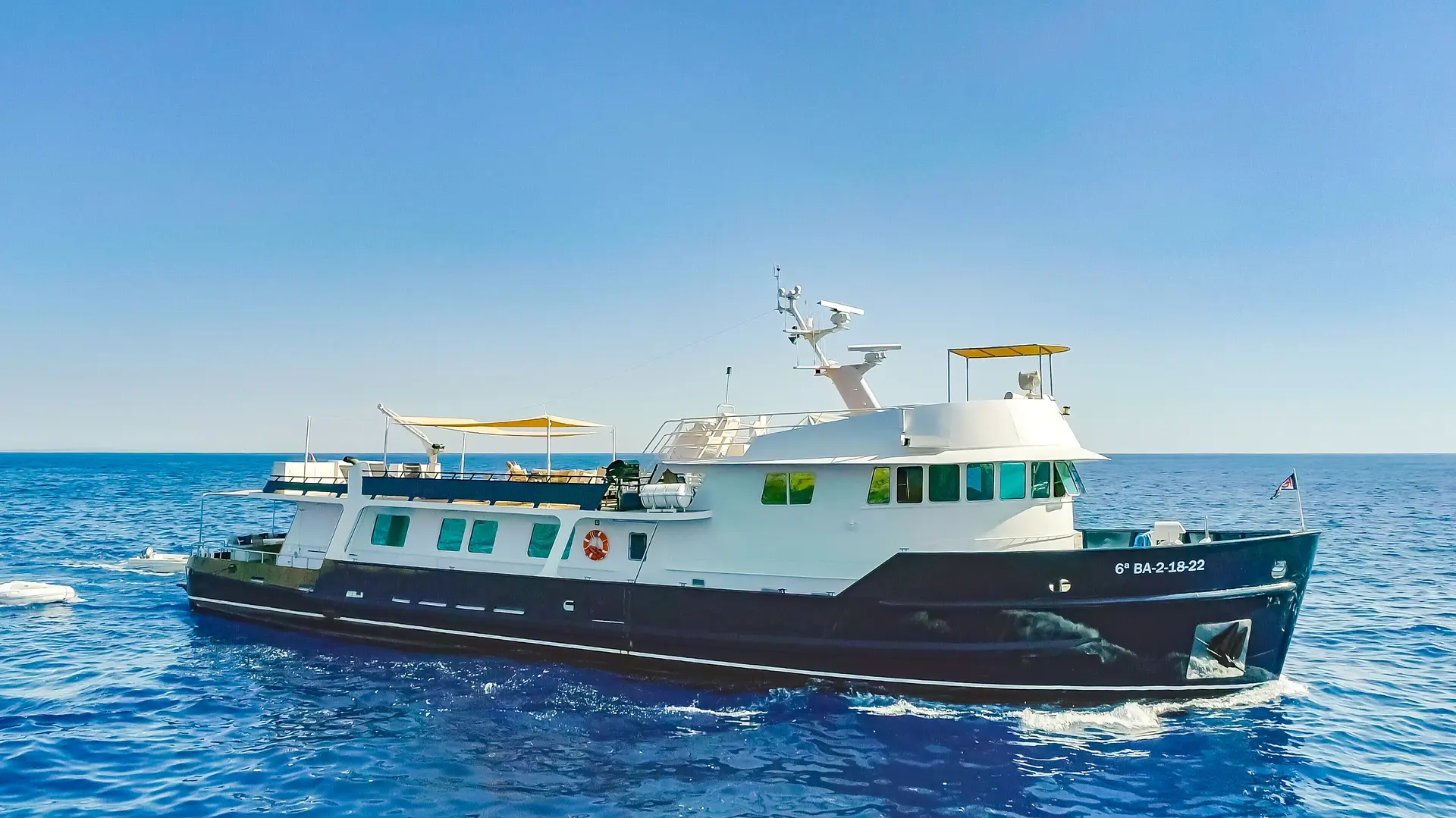 Halter Marine 33 — Bateau à moteur blanc et bleu naviguant en mer sous un ciel dégagé.