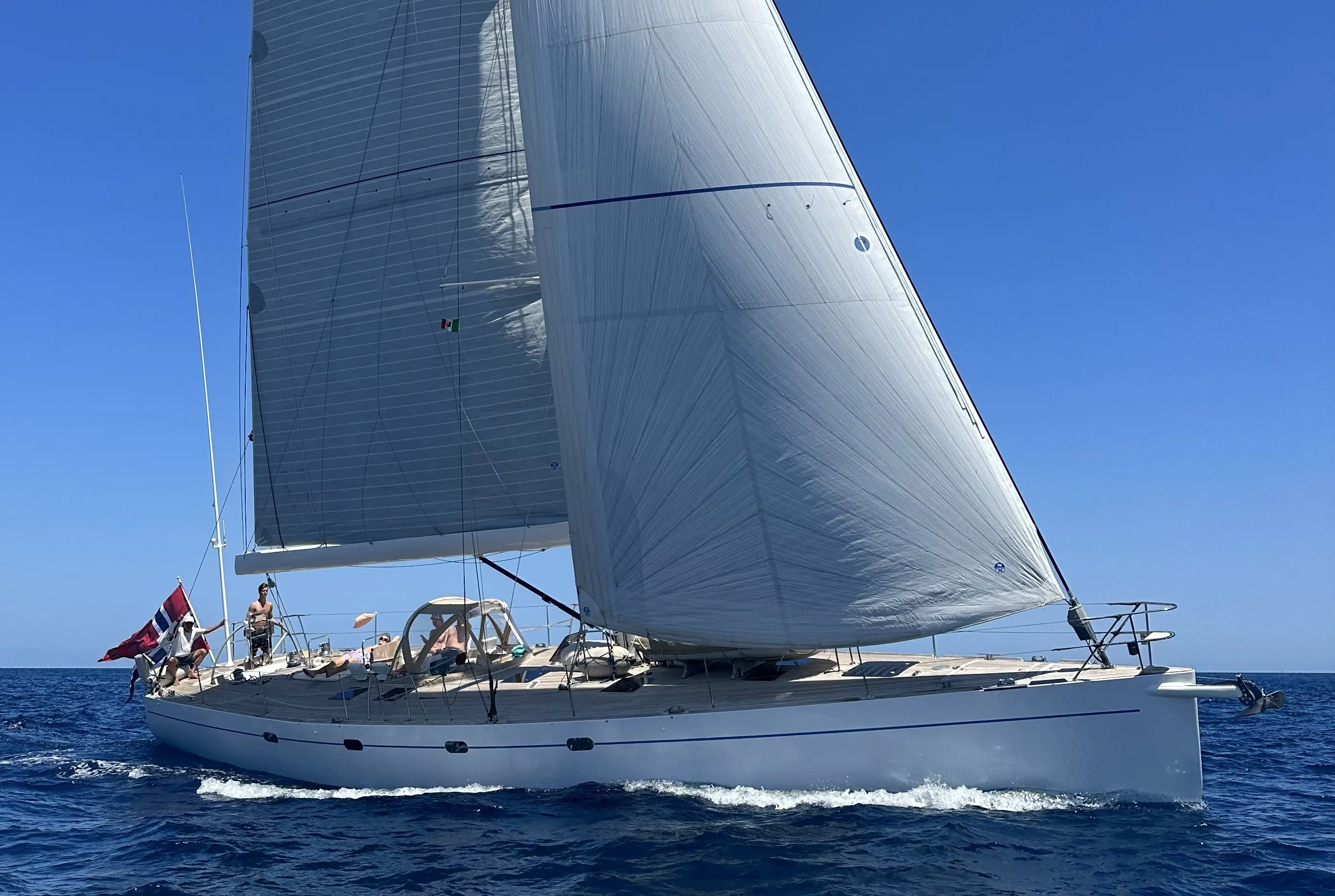 Vismara V60 — Voilier blanc naviguant sous voiles par mer calme et ciel dégagé.