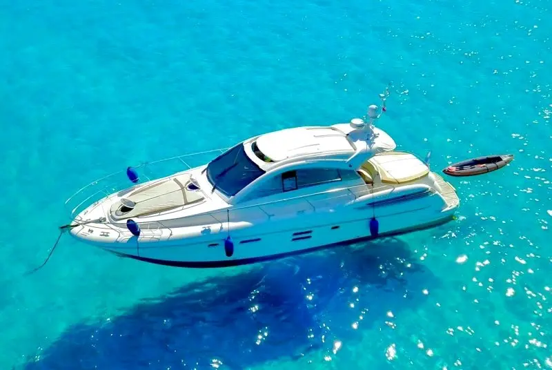Jeanneau Prestige 50 — Vue aérienne d’un bateau à moteur blanc dans une eau turquoise.