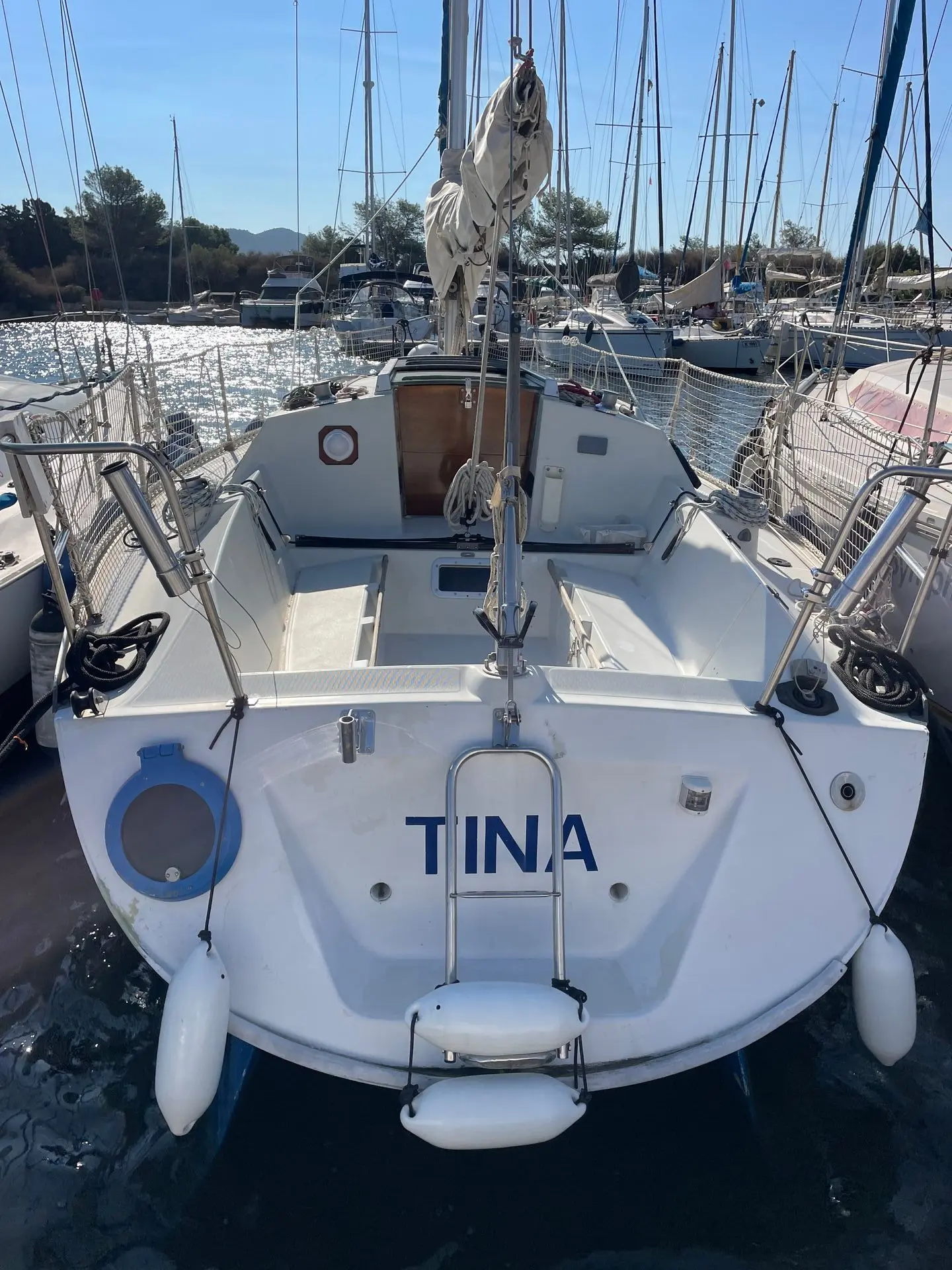 Beneteau First 29 — Vue arrière du voilier TINA amarré dans un port, avec cockpit et gréement visibles.