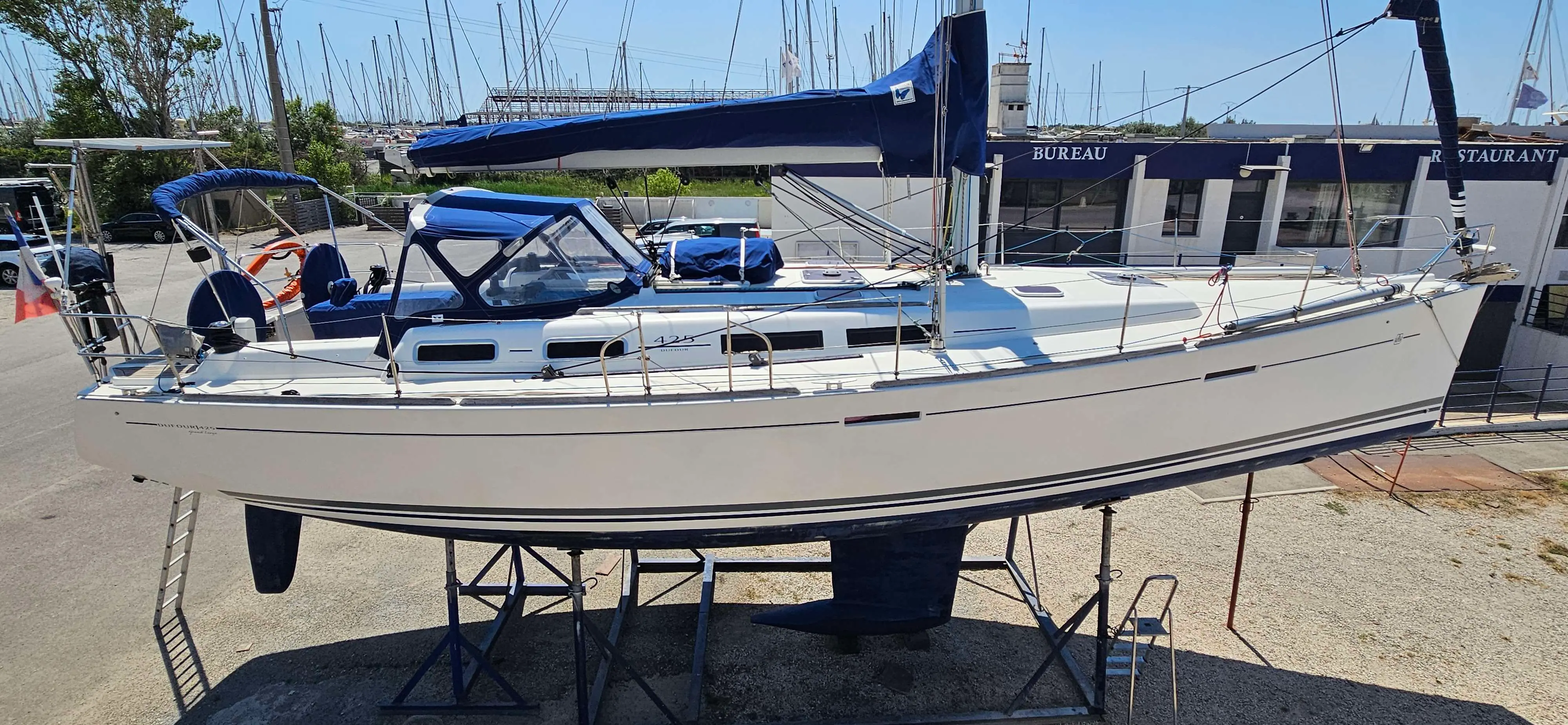 Dufour 425 — Voilier blanc présenté à terre, vu de profil dans un port à sec.