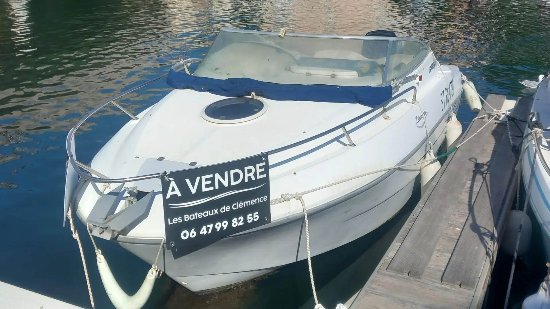 Sessa Marine Islamorada 19 — Bateau à moteur blanc amarré à un ponton, avec pare-brise et panneau « À vendre ».
