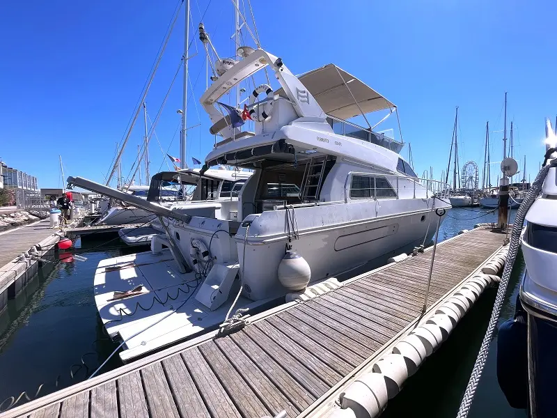 Ferretti Altura 45 Fly — Yacht blanc à moteur amarré dans une marina, vu de trois quarts arrière.