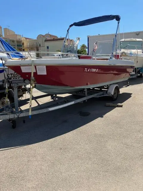 Ultramar Ultra 570 Open — Bateau de plaisance rouge et blanc sur remorque, photographié à terre.