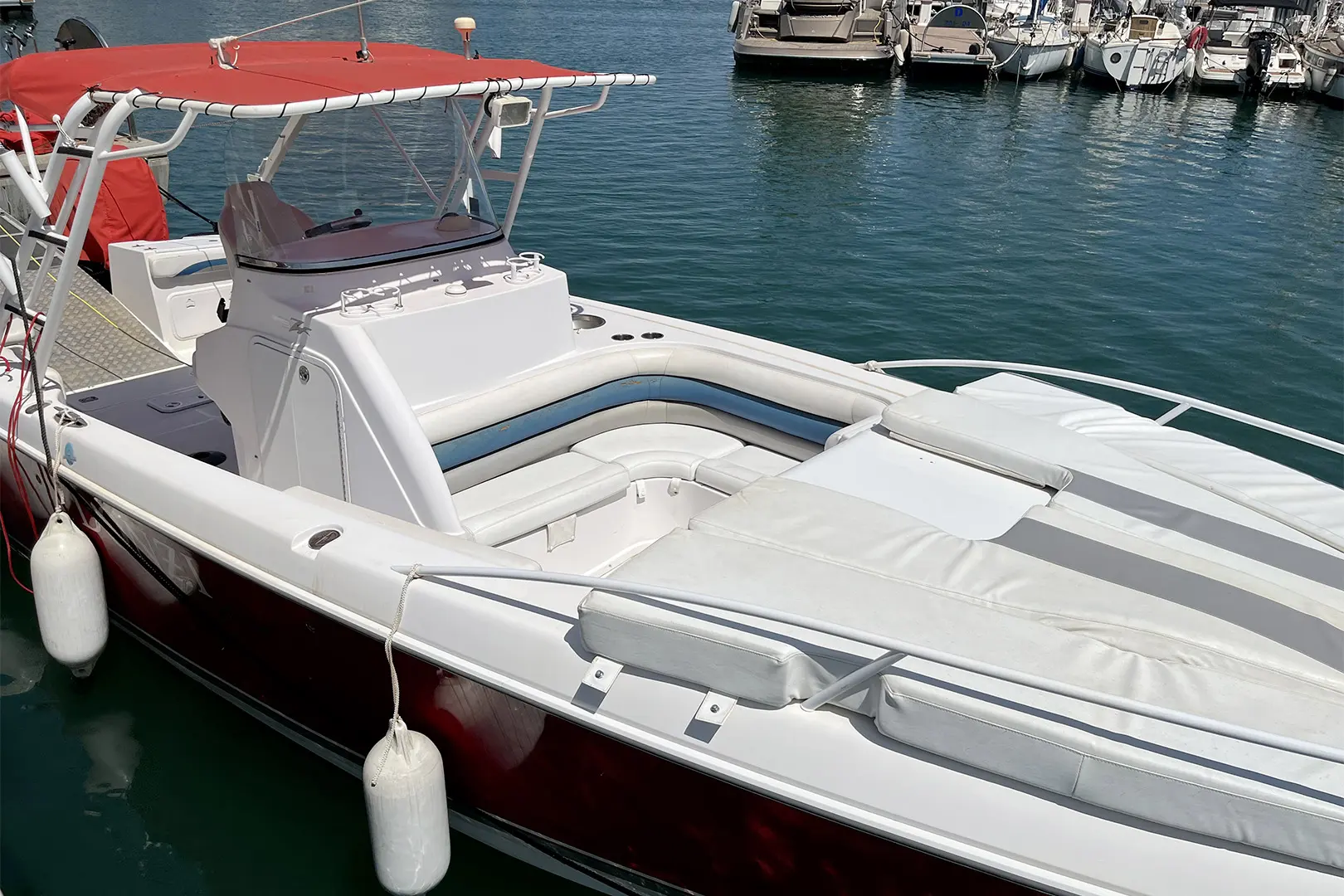 Donzi 35 ZFX — Bateau de plaisance blanc et rouge amarré, avec cockpit ouvert et bain de soleil.