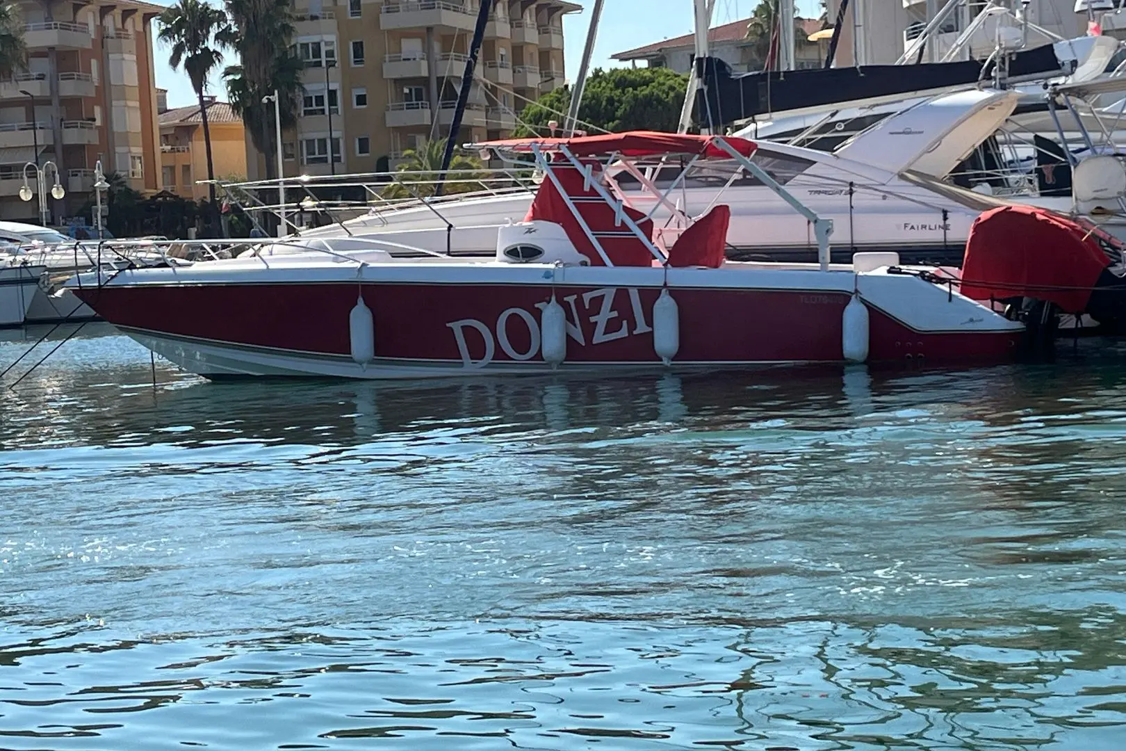 Donzi 35 ZFX — Bateau rouge et blanc amarré dans une marina, vu de profil.