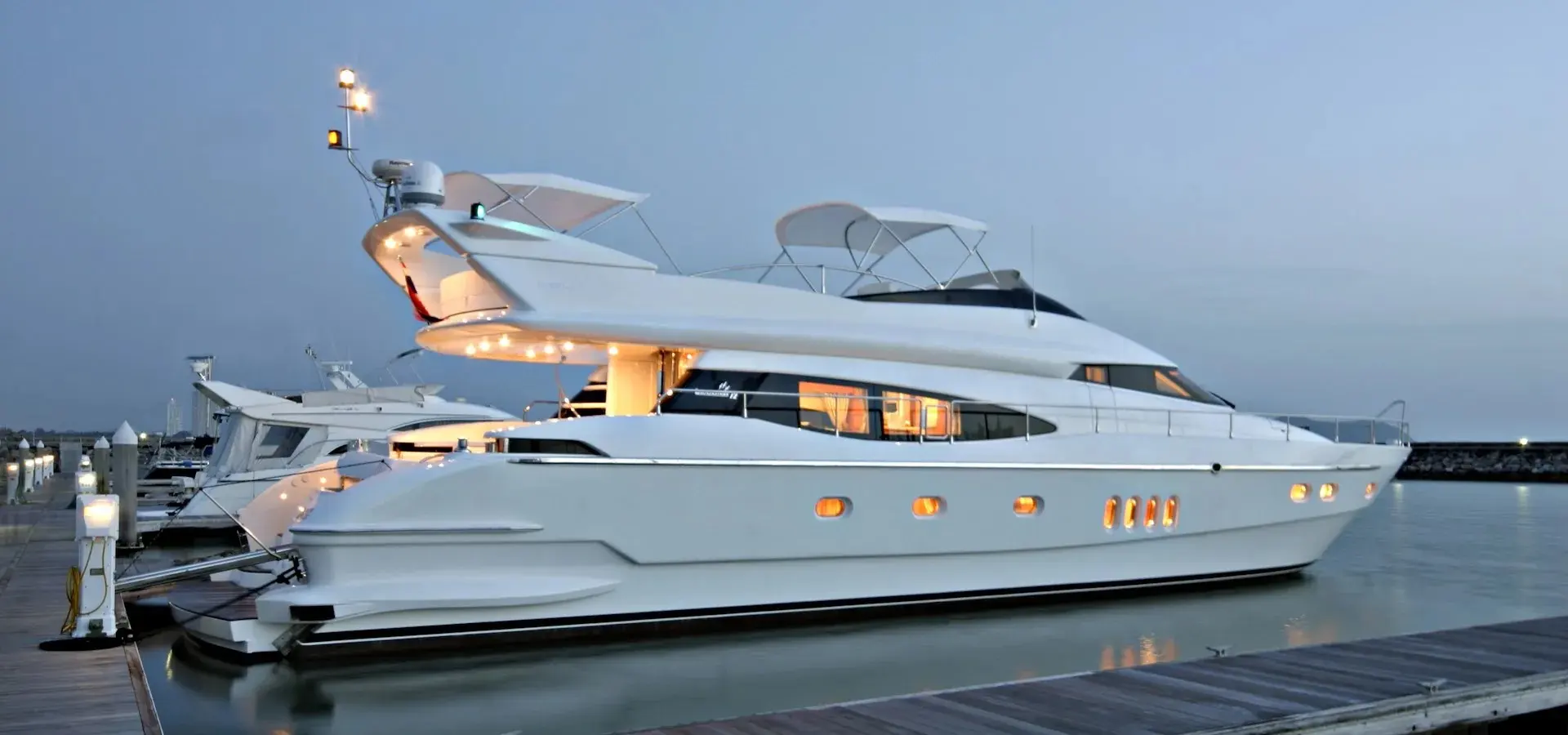 Ladenstein 72 Fly — Yacht blanc amarré dans une marina, photographié de profil au crépuscule.