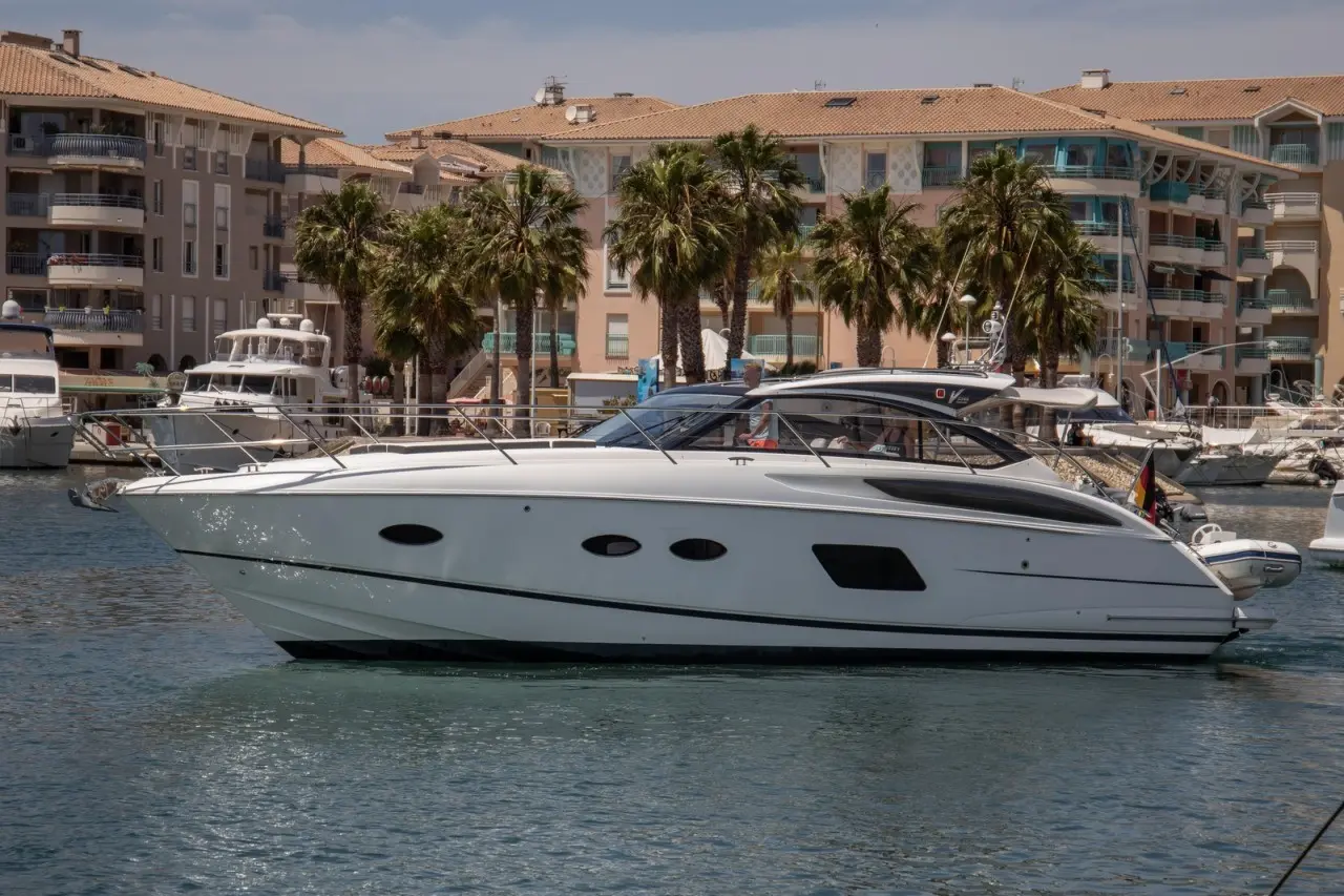 Princess V39 — Bateau à moteur blanc photographié de profil dans un port bordé de palmiers.