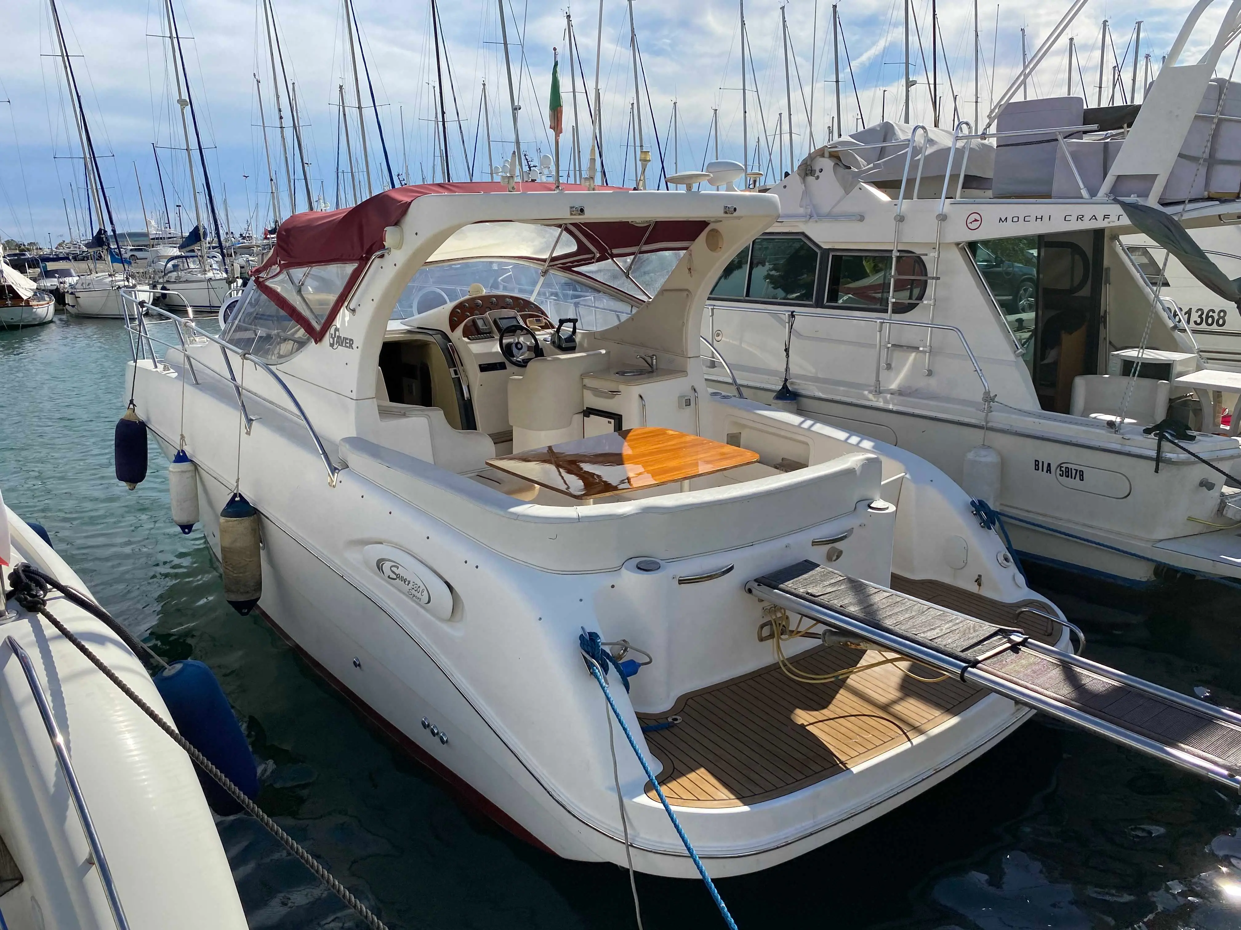 Saver 330 Sport — Vedette à moteur blanche amarrée dans un port, vue de trois quarts arrière.