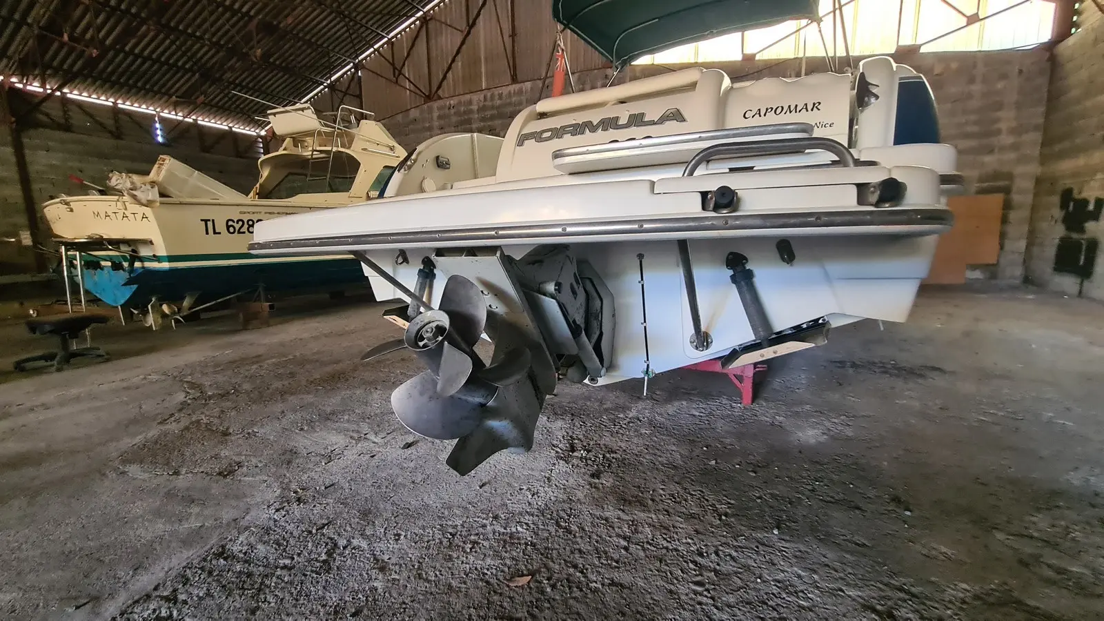 Formula 260 — Vue arrière d’un bateau à moteur Formula, avec hélices visibles dans un hangar.