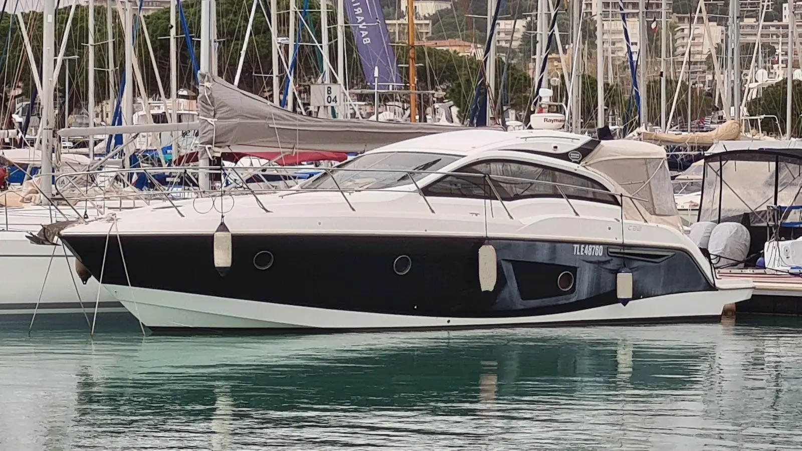 Sessa Marine C38 — Bateau à moteur blanc et noir amarré dans un port de plaisance.