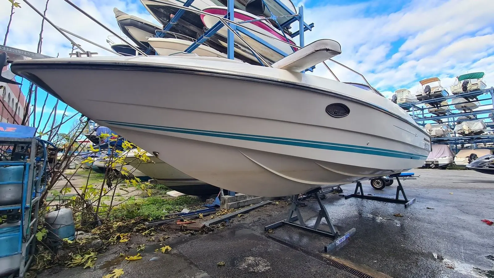 Sunseeker Mohawk 29 — Bateau à moteur blanc à liseré bleu, posé sur bers dans un chantier nautique.