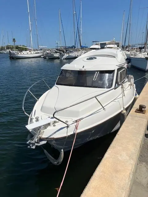 Quicksilver Activ 640 Weekend — Bateau à moteur blanc amarré dans une marina, vu de trois quarts avant.