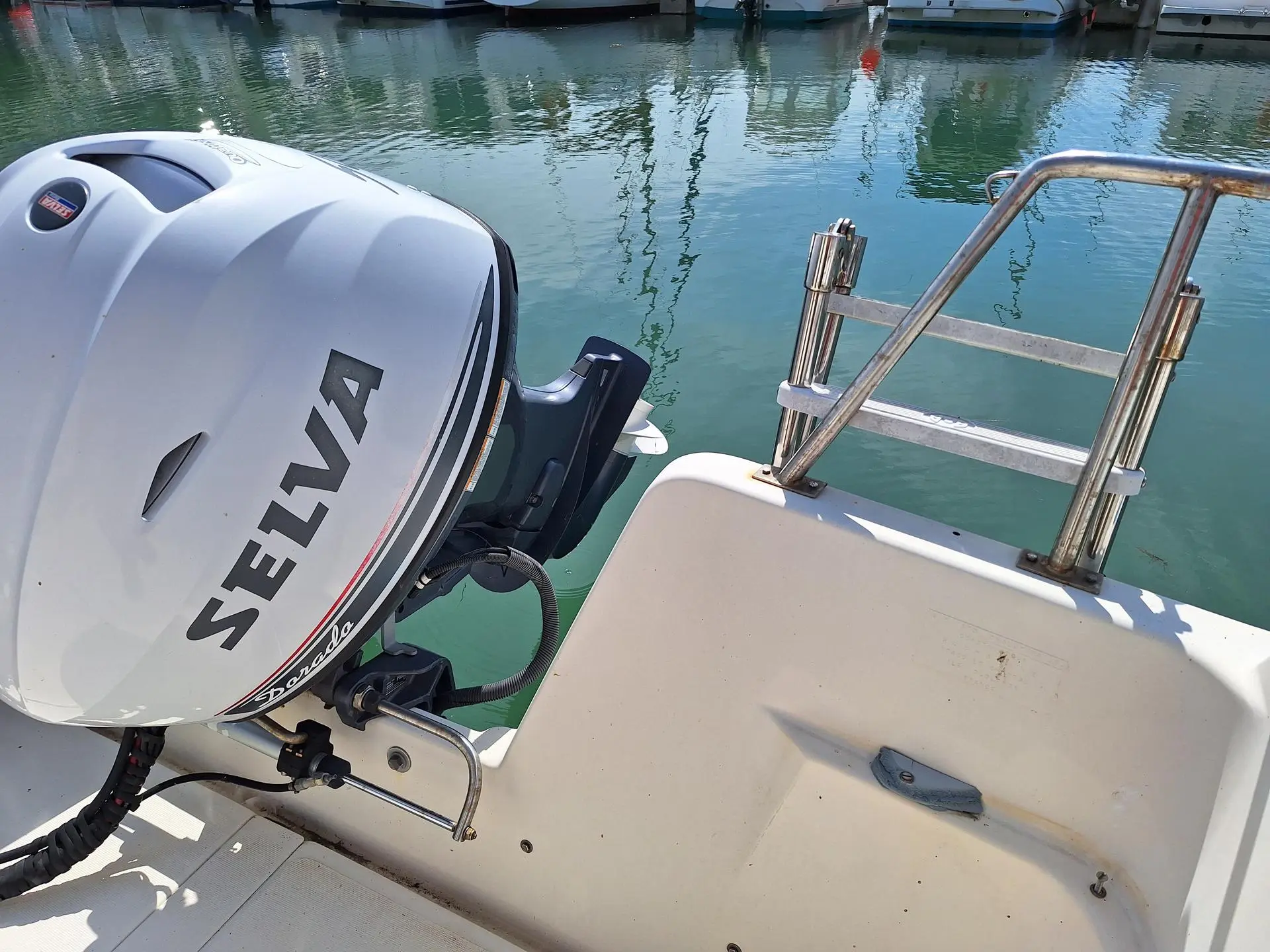 Guymarine GM 570 Chalutier — Vue rapprochée du moteur hors-bord et de la poupe du bateau au port.
