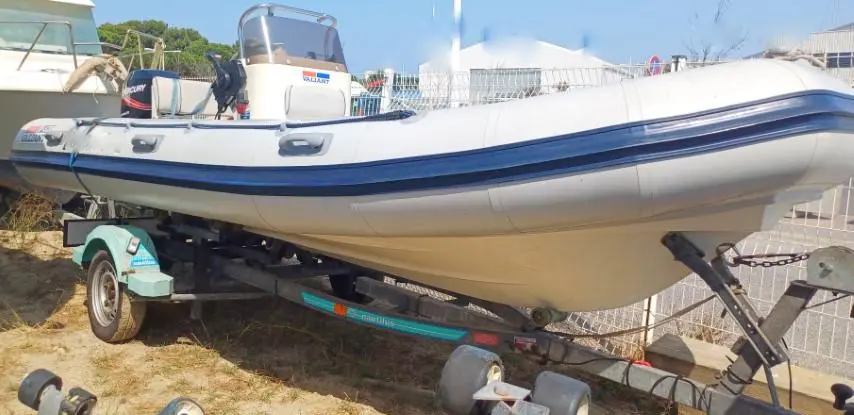 Valiant 520 — Bateau pneumatique blanc et bleu présenté sur une remorque, vu de trois quarts.