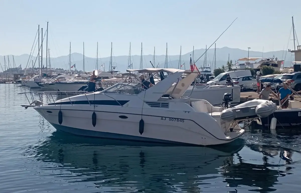 Bayliner Avanti 3055 — Bateau à moteur blanc amarré dans un port, vu de profil latéral.