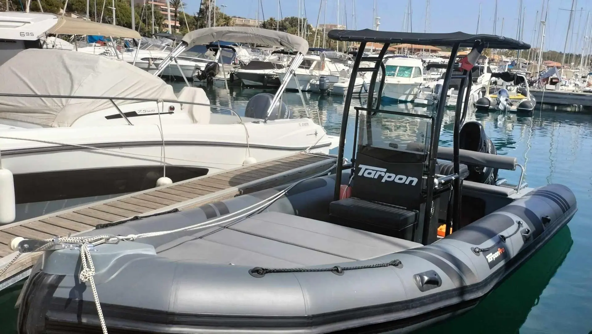 Tarpon DV 62 — Bateau semi-rigide gris équipé d’une console centrale, amarré dans un port.