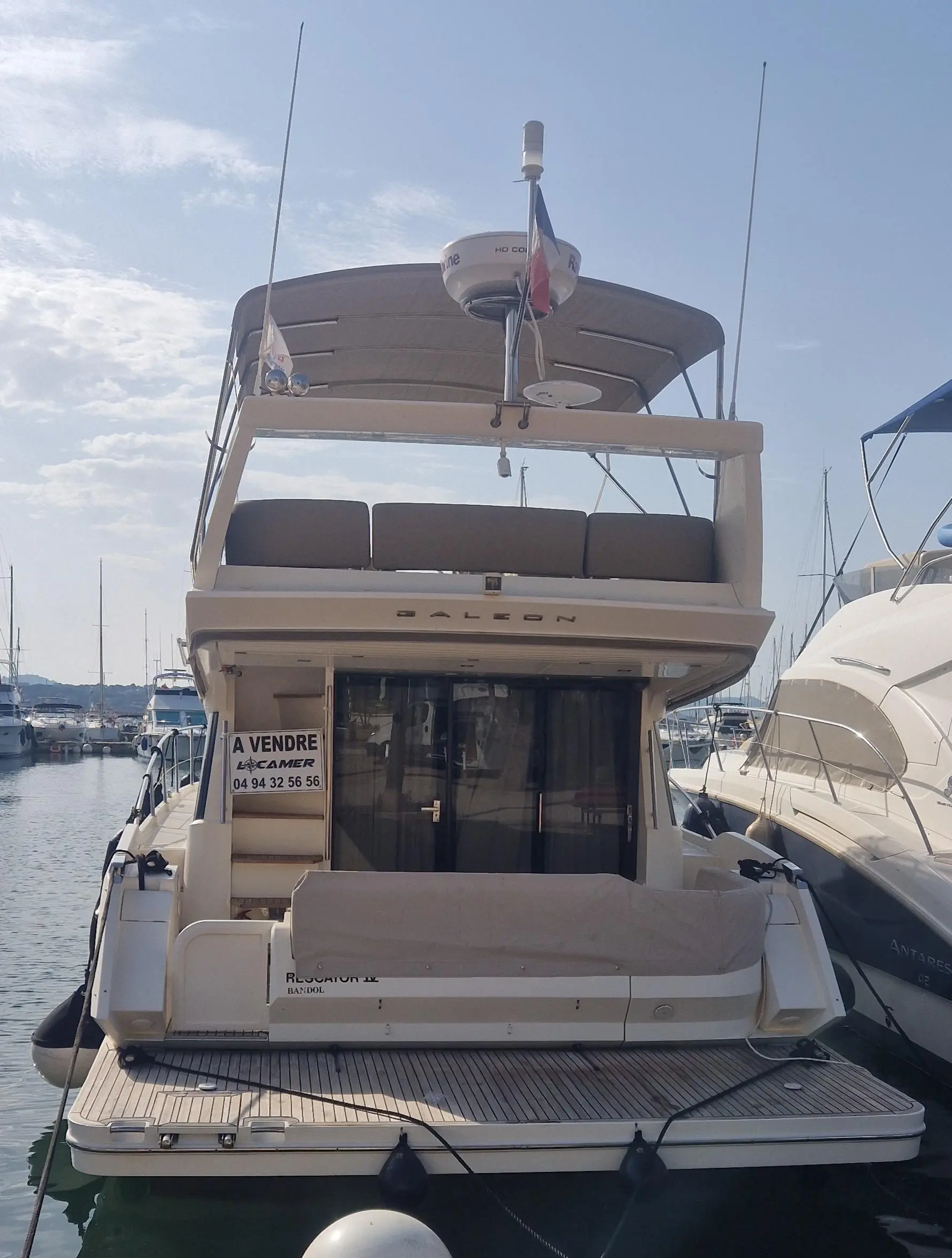 Galeon 420 Fly — Vue arrière d’un yacht à moteur amarré dans un port, avec flybridge et cockpit.