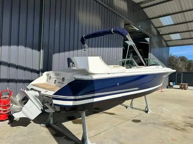 Chris Craft Launch 25 — Bateau à moteur bleu et blanc présenté sur sa remorque, vu de trois quarts arrière.