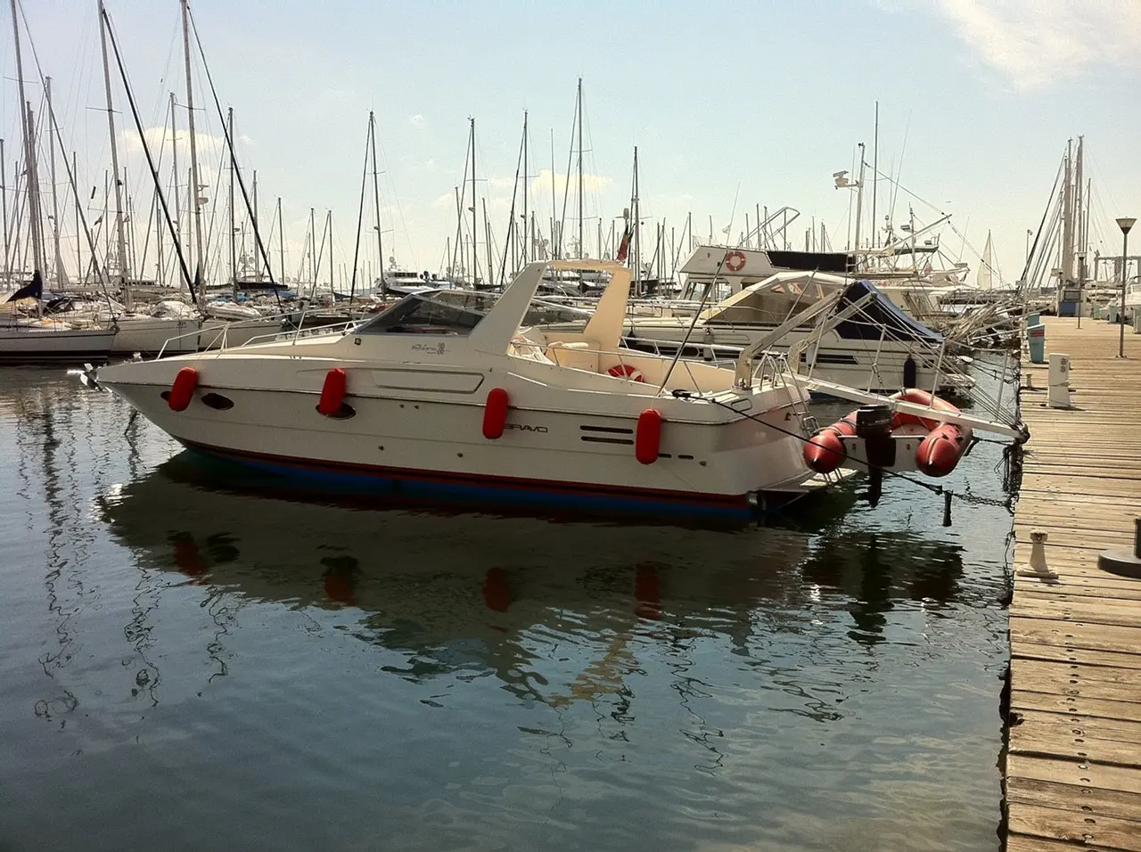 Riva 38 Bravo — Bateau à moteur blanc amarré dans un port de plaisance, vu de profil.