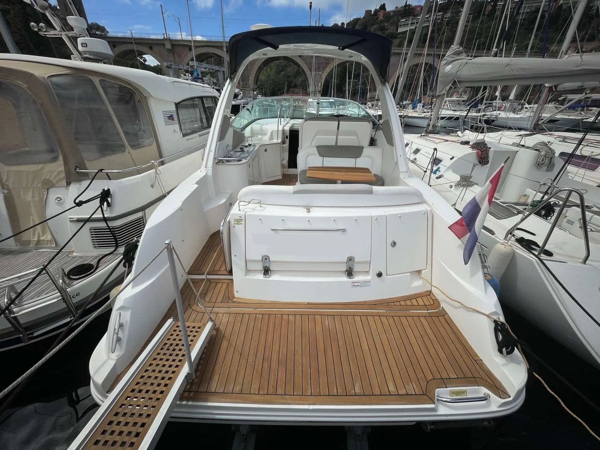 Sea Ray 335 — Vue arrière du cockpit ouvert d’un bateau amarré dans une marina.