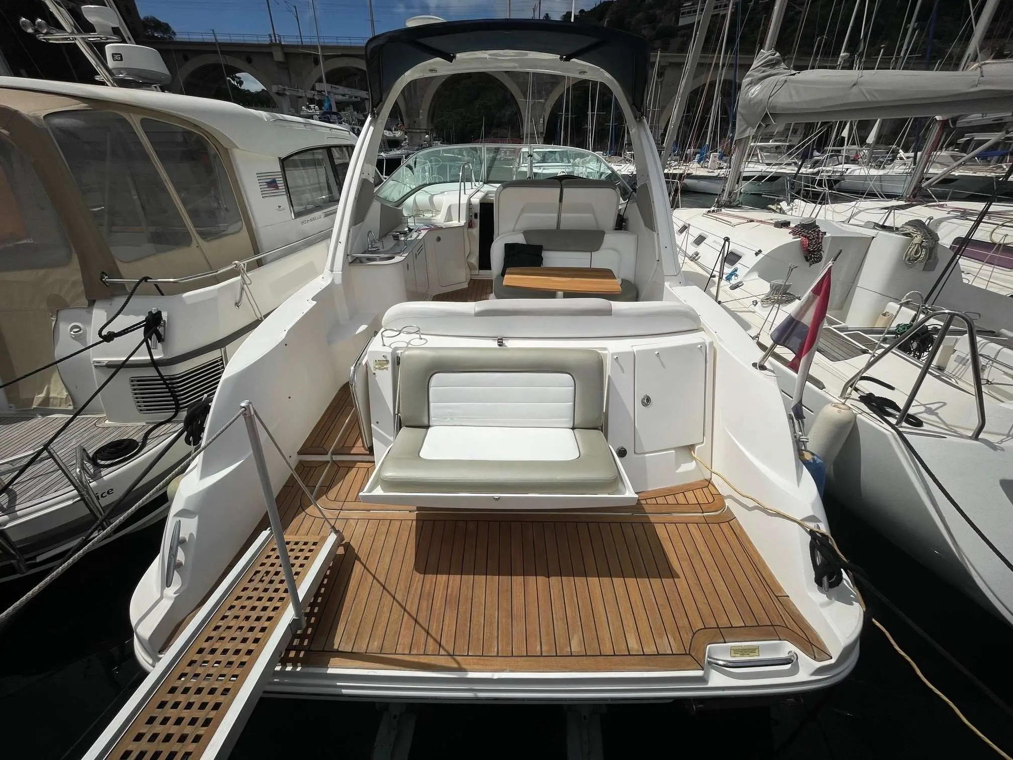 Sea Ray 335 — Vue arrière du cockpit et de la plage arrière d’un bateau amarré au port.