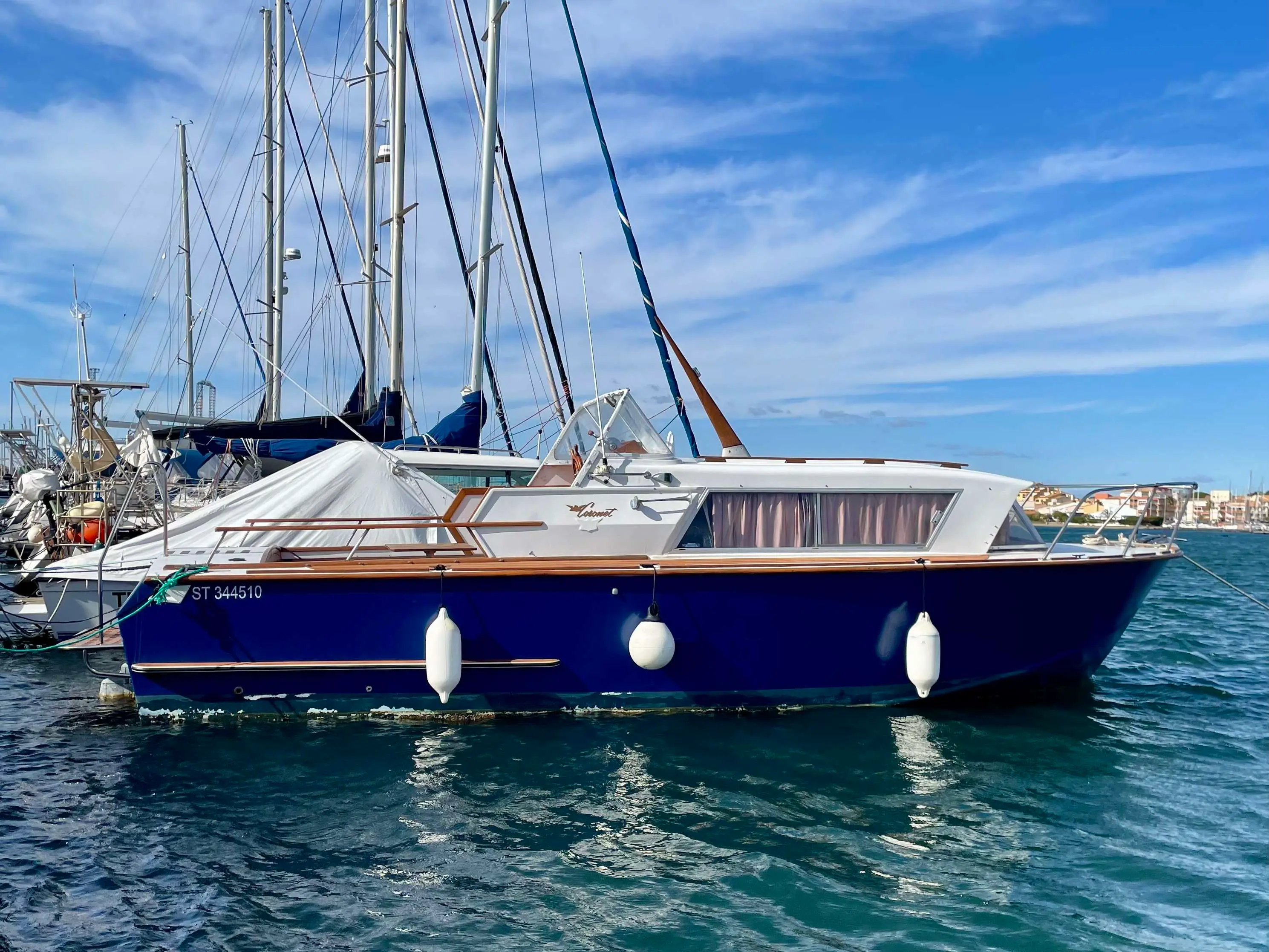 Coronet 27 Sea Farer — Bateau à moteur bleu et blanc amarré dans un port, vu de profil.