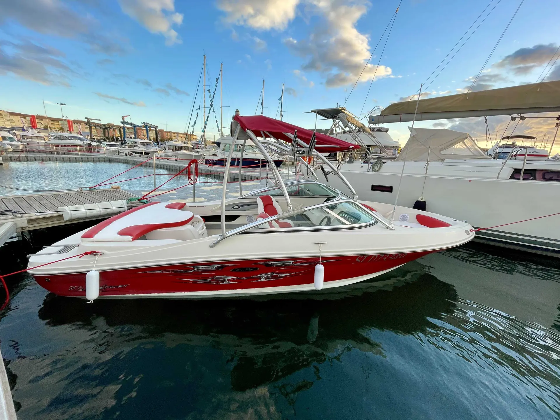 Sea Ray 205 Sport — Bateau de plaisance rouge et blanc amarré dans un port de plaisance.