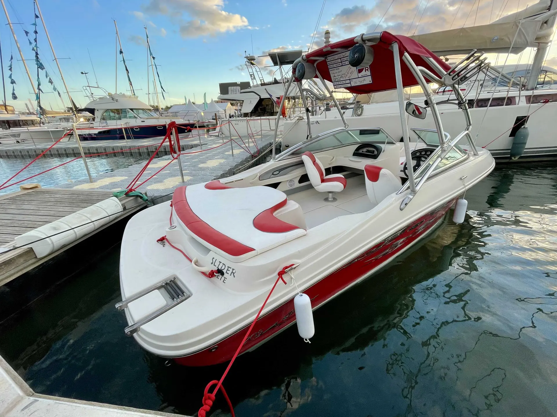 Sea Ray 205 Sport — Bateau à moteur blanc et rouge amarré dans un port de plaisance.