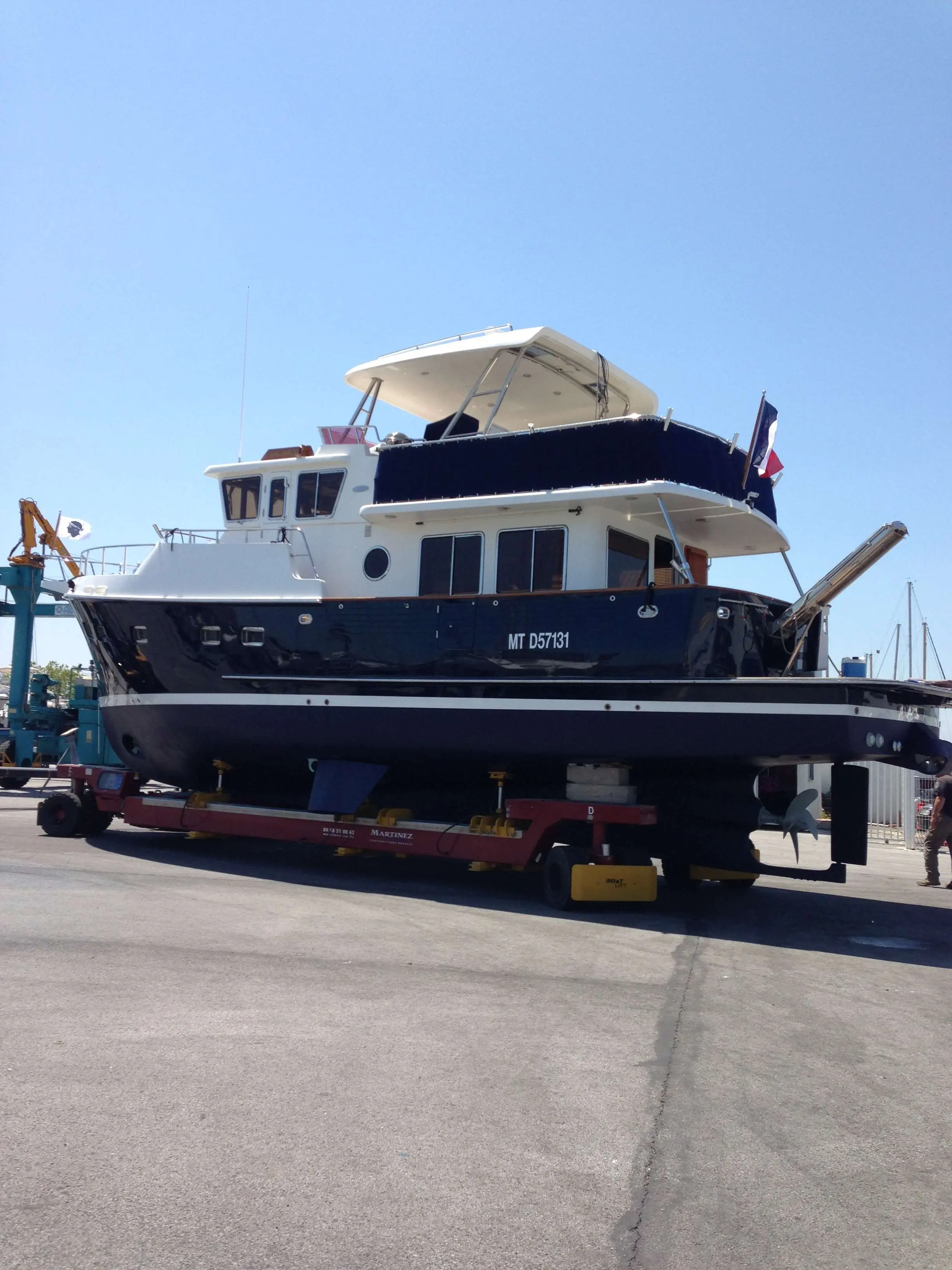 Selene 43 — Bateau à moteur bleu et blanc photographié à terre sur une remorque de chantier.