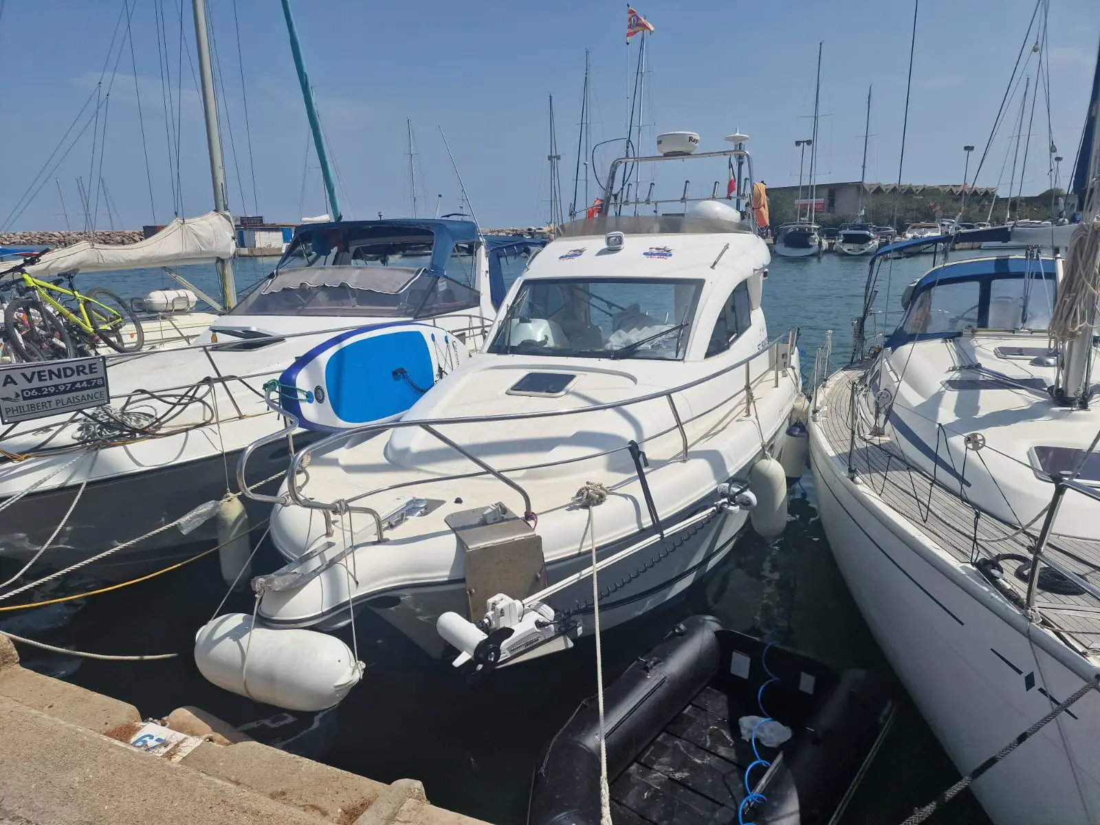 ST Boats Starfisher 30 Cruiser — Bateau à moteur blanc amarré dans un port, vu de trois quarts avant.
