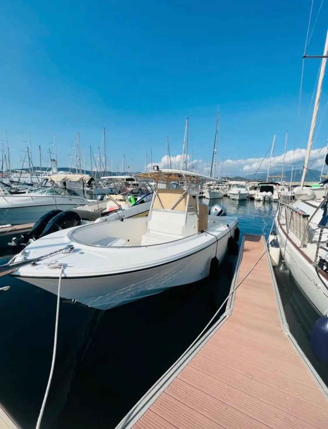 Edge Water 265 CC — Bateau à moteur blanc amarré dans une marina, vu de trois quarts avant.