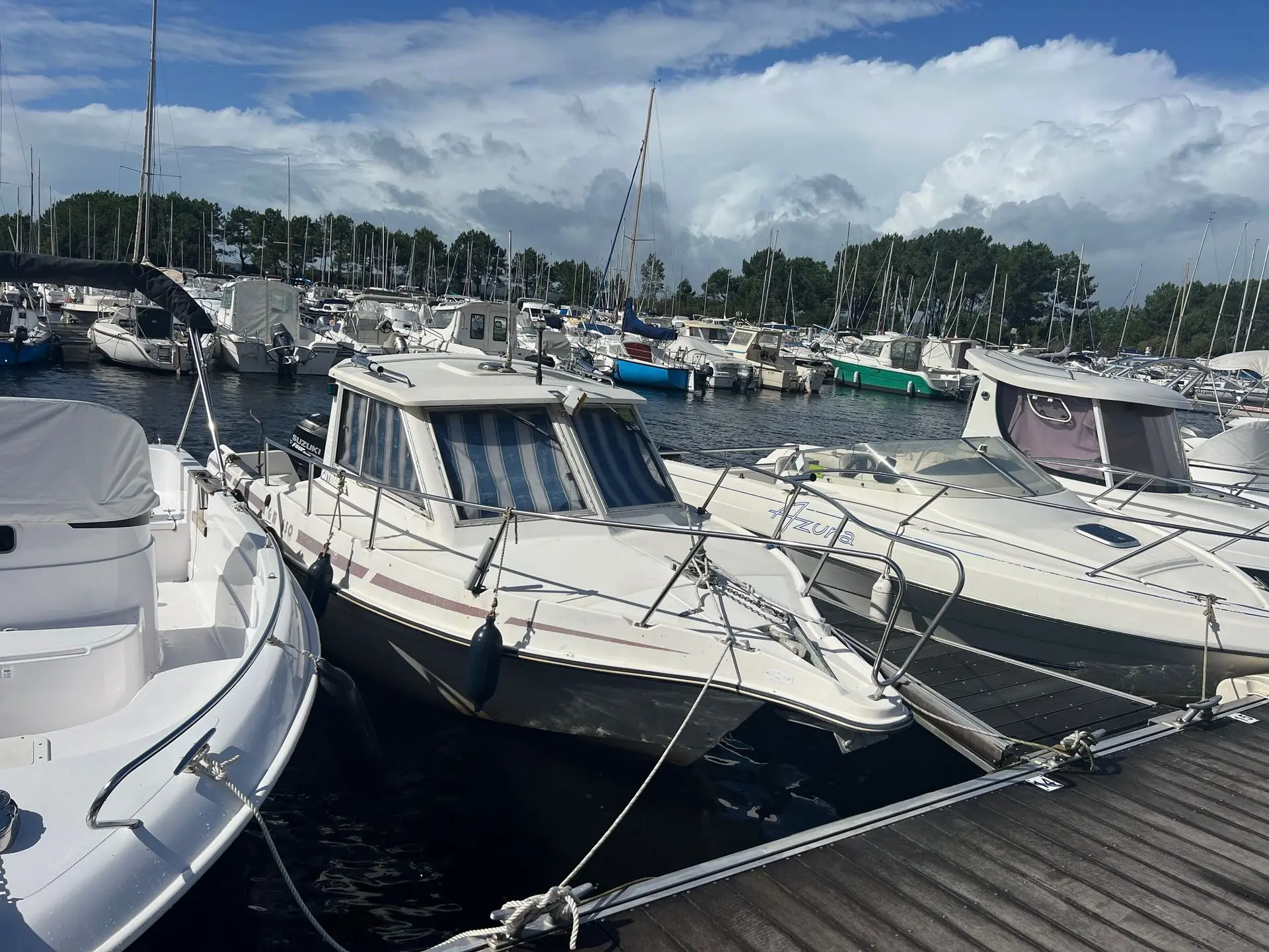 Guymarine GM 650 — Bateau à cabine amarré dans un port de plaisance, entre d'autres embarcations.