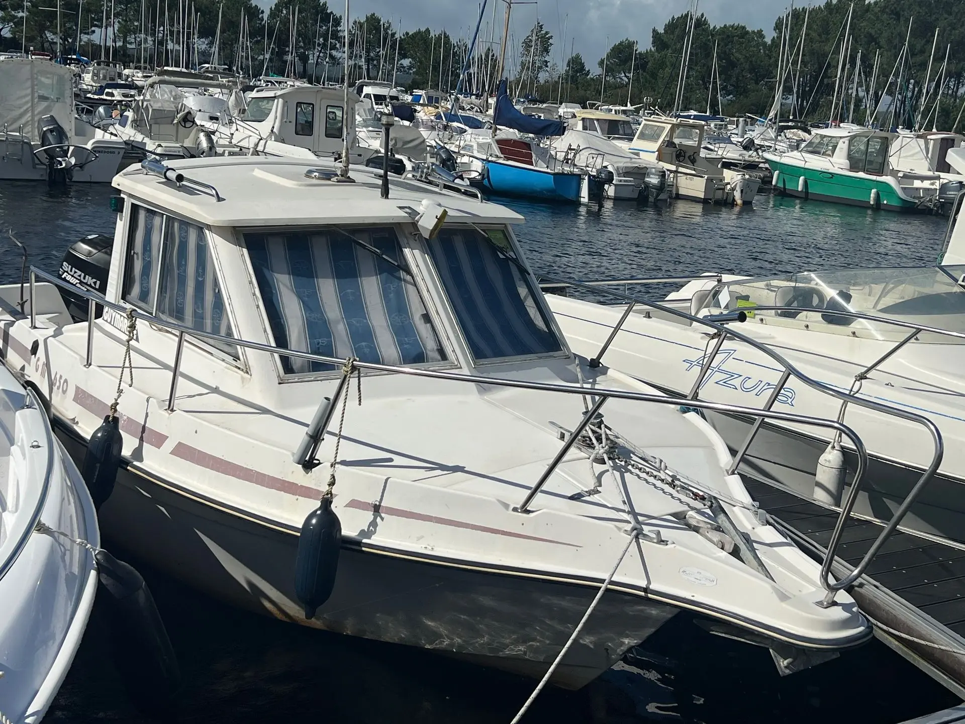 Guymarine GM 650 — Bateau à moteur blanc amarré dans un port, photographié de trois quarts avant.