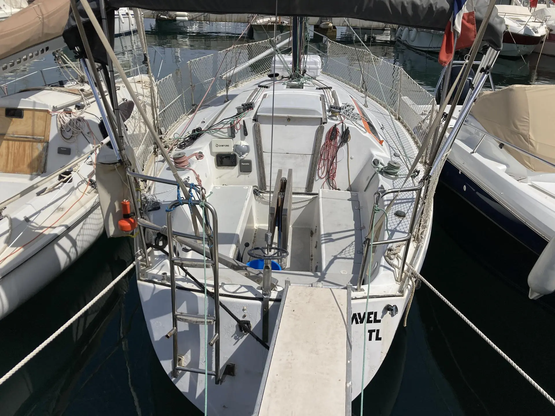 Neptune Smap Trident 80 — Vue arrière du cockpit et du pont d’un voilier amarré dans une marina.