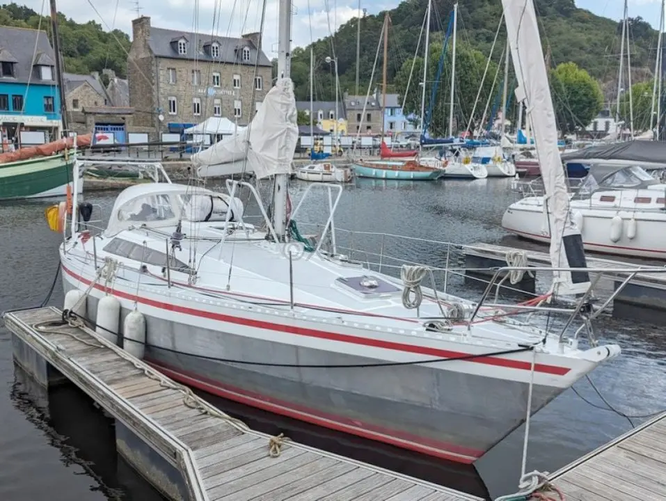 Alubat Ovni 35 — Voilier blanc à bandes rouges amarré dans un port de plaisance.
