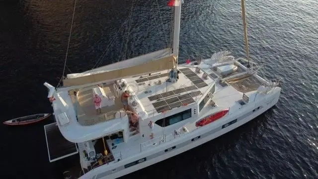 Squalt Marine International CK64 — Vue aérienne d’un catamaran blanc sur l’eau, avec une annexe à proximité.