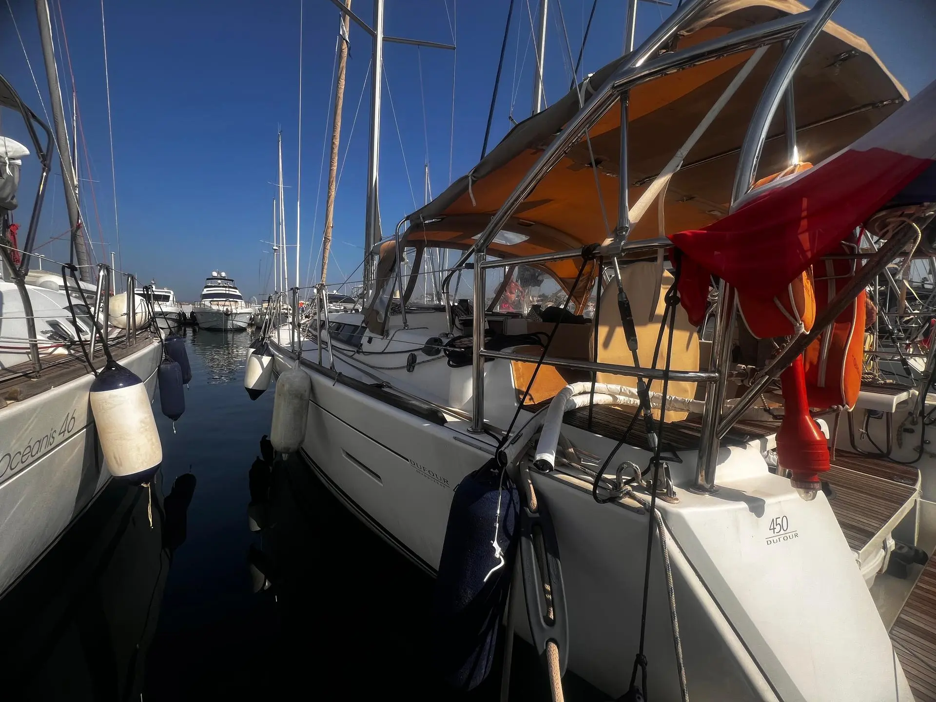 Dufour 450 — Voilier Dufour amarré dans une marina, vu de l’arrière tribord.