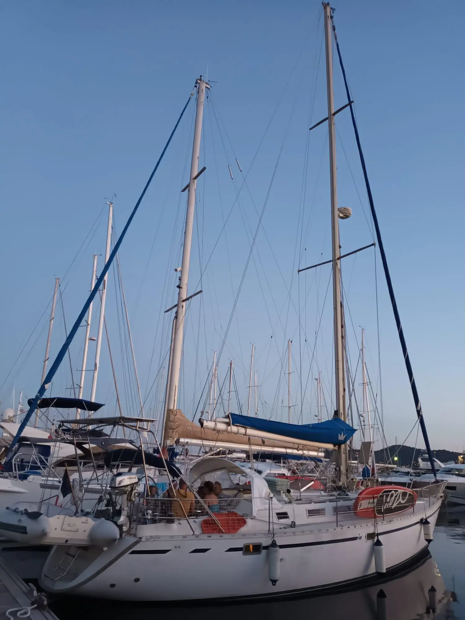 Gib Sea 442 — Voilier blanc amarré dans une marina, entouré d'autres bateaux.