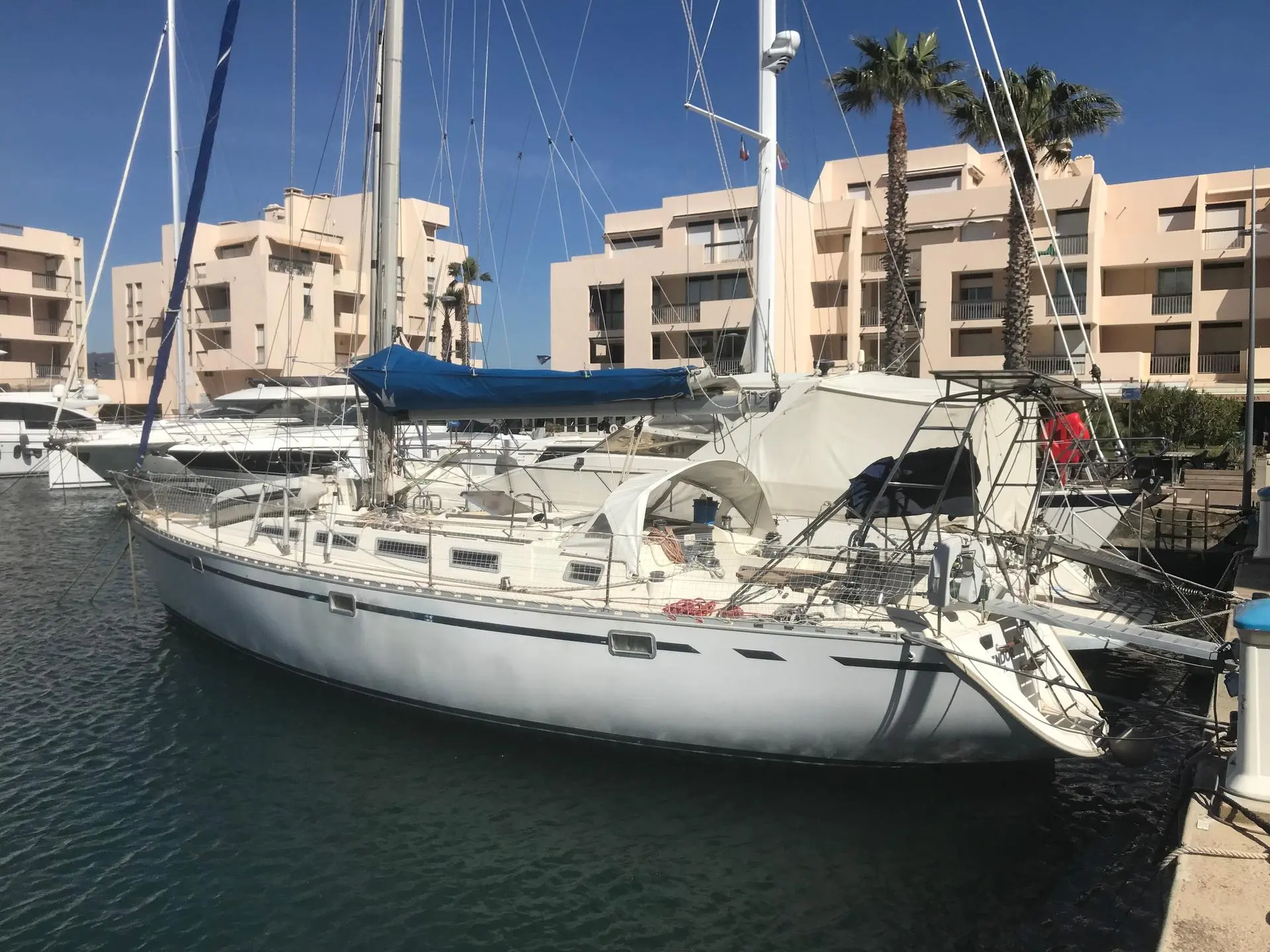 Gib Sea 442 — Voilier blanc amarré dans un port, photographié de trois quarts.