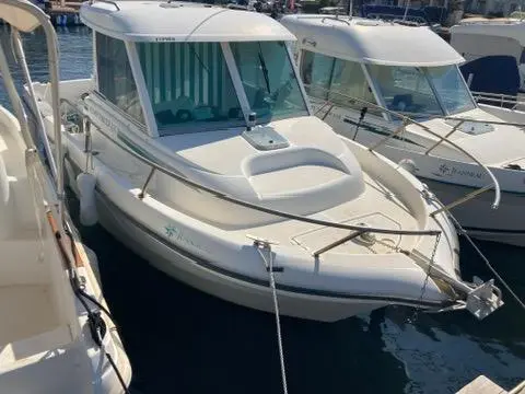 Jeanneau Merry Fisher 635 — Bateau à cabine amarré dans un port, vu de trois quarts avant.