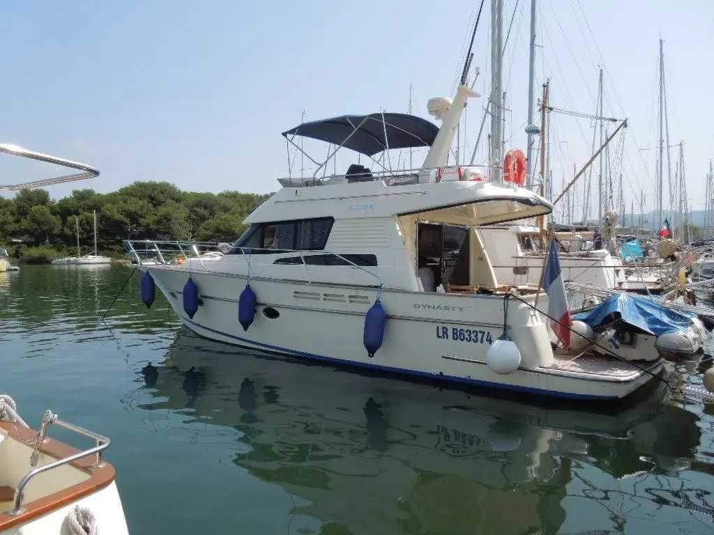 ACM Dynasty 43 — Bateau à moteur blanc amarré dans un port, vu de trois quarts.