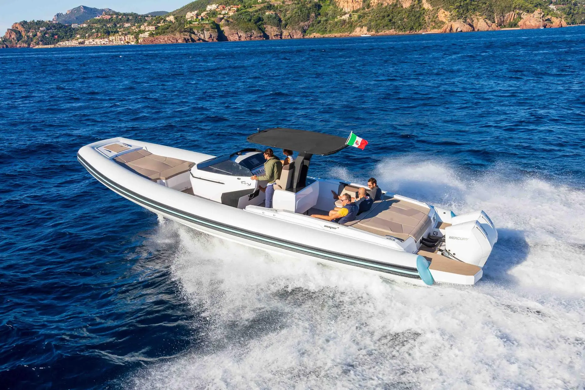 Rio Yachts Inagua — Bateau semi-rigide blanc naviguant au large avec plusieurs passagers à bord.