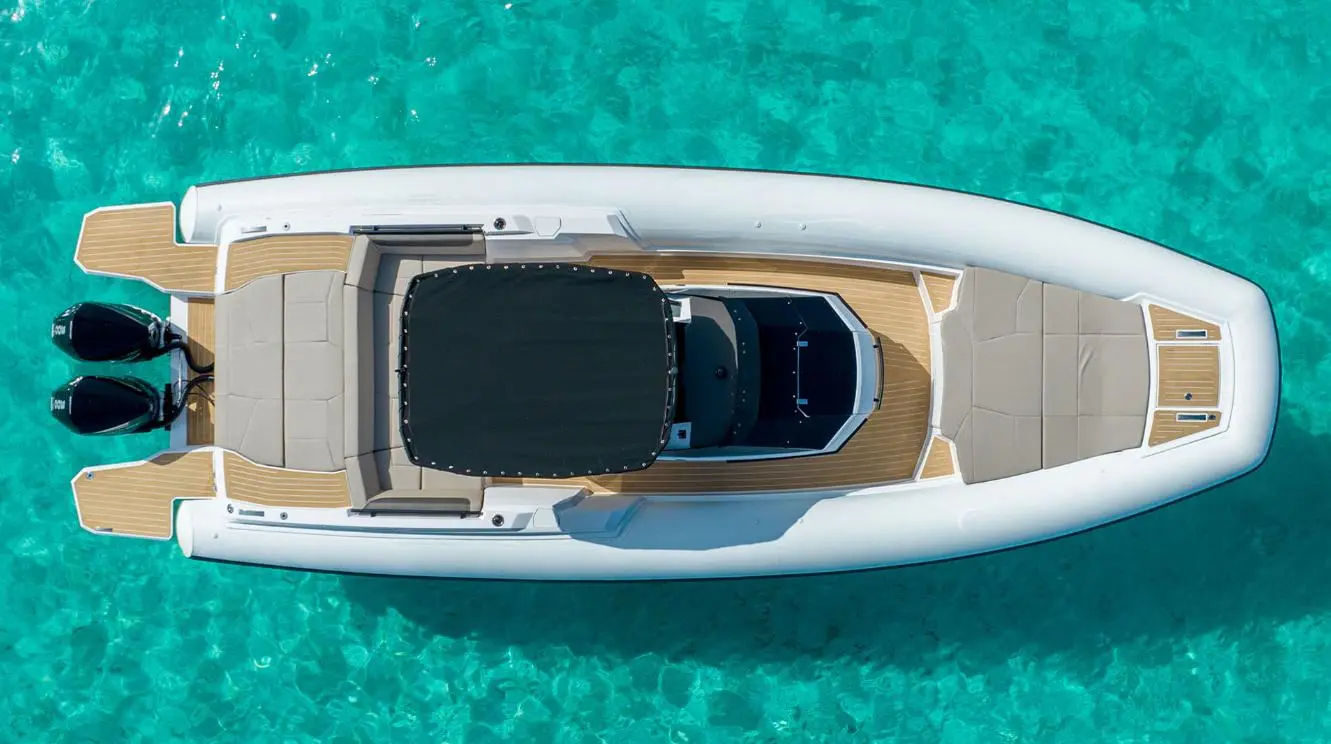 Rio Yachts Inagua — Vue aérienne d’un bateau pneumatique à deux moteurs hors-bord sur une eau turquoise.
