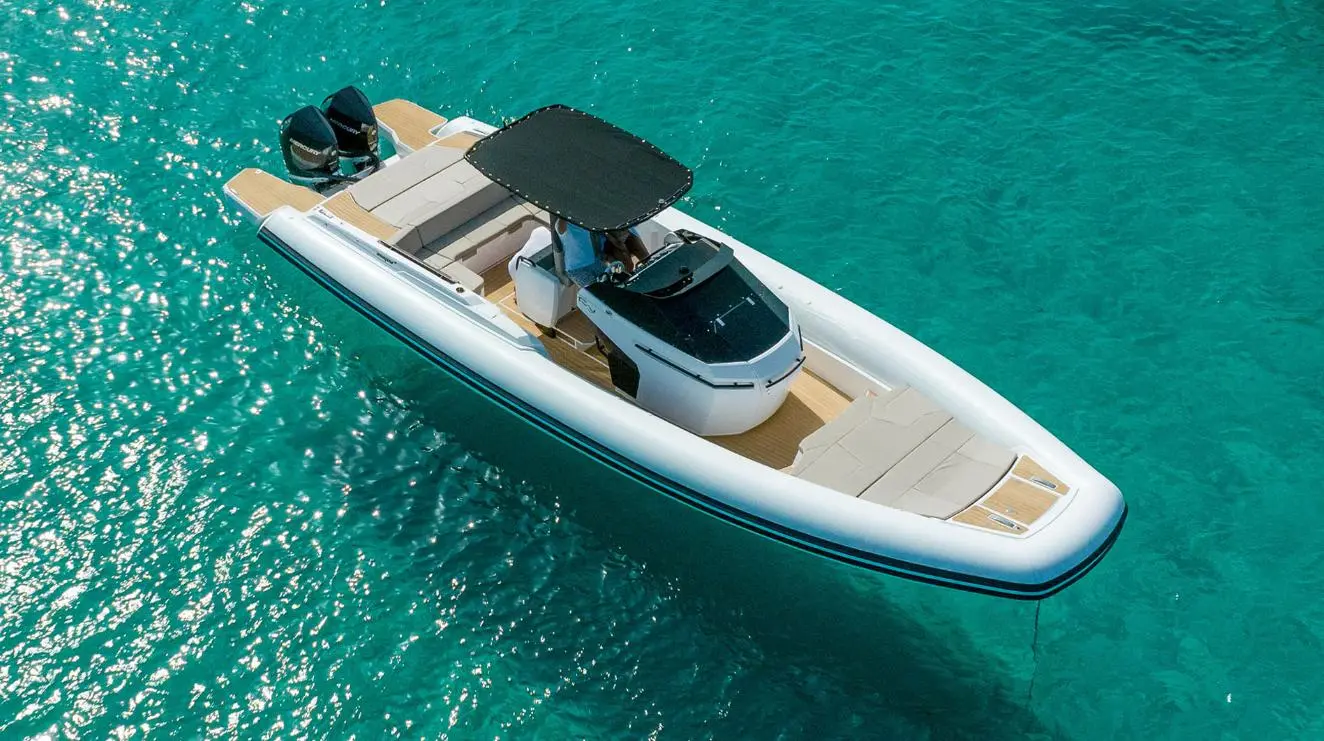 Rio Yachts Inagua — Vue aérienne d’un bateau pneumatique à deux moteurs hors-bord sur une mer turquoise.