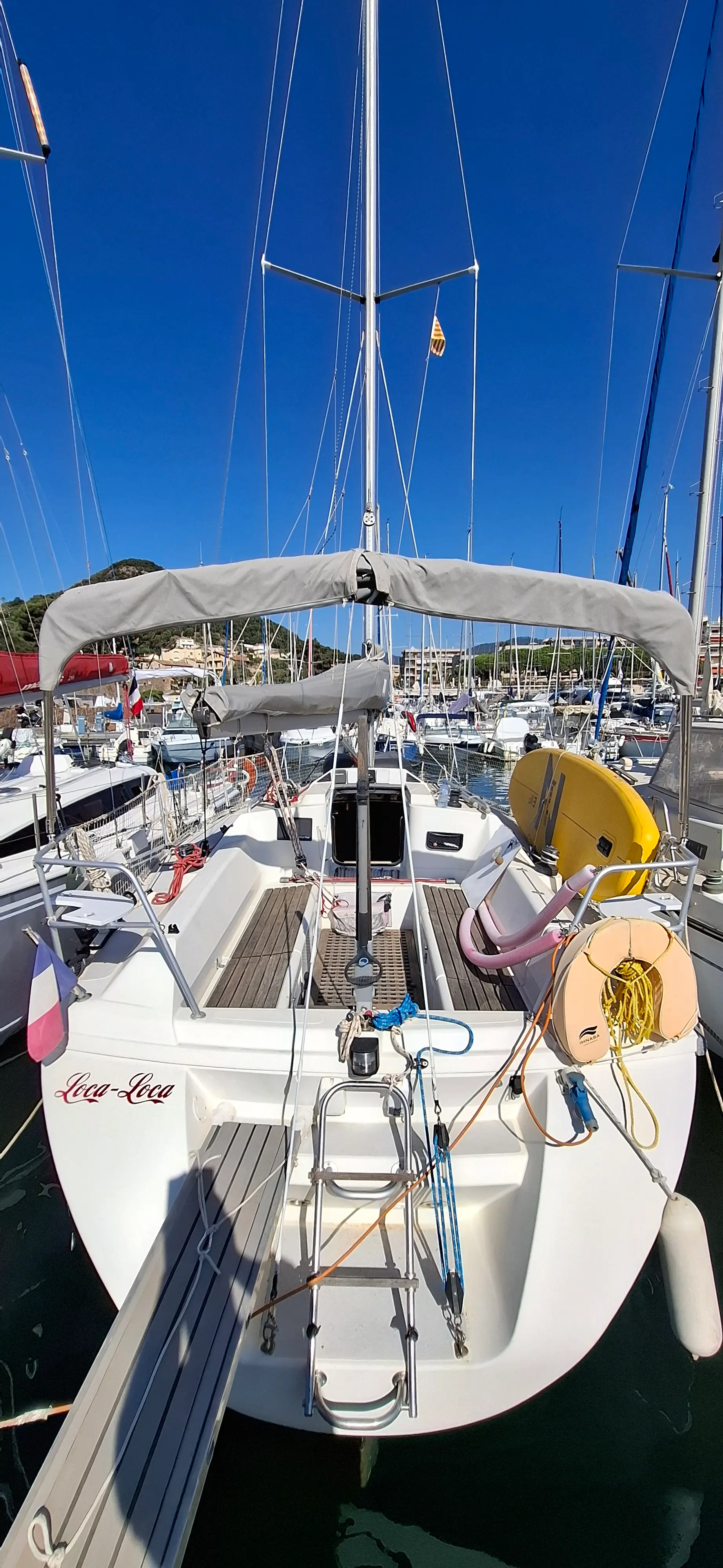 Etap 32 i — Vue arrière du cockpit d’un voilier amarré dans un port.