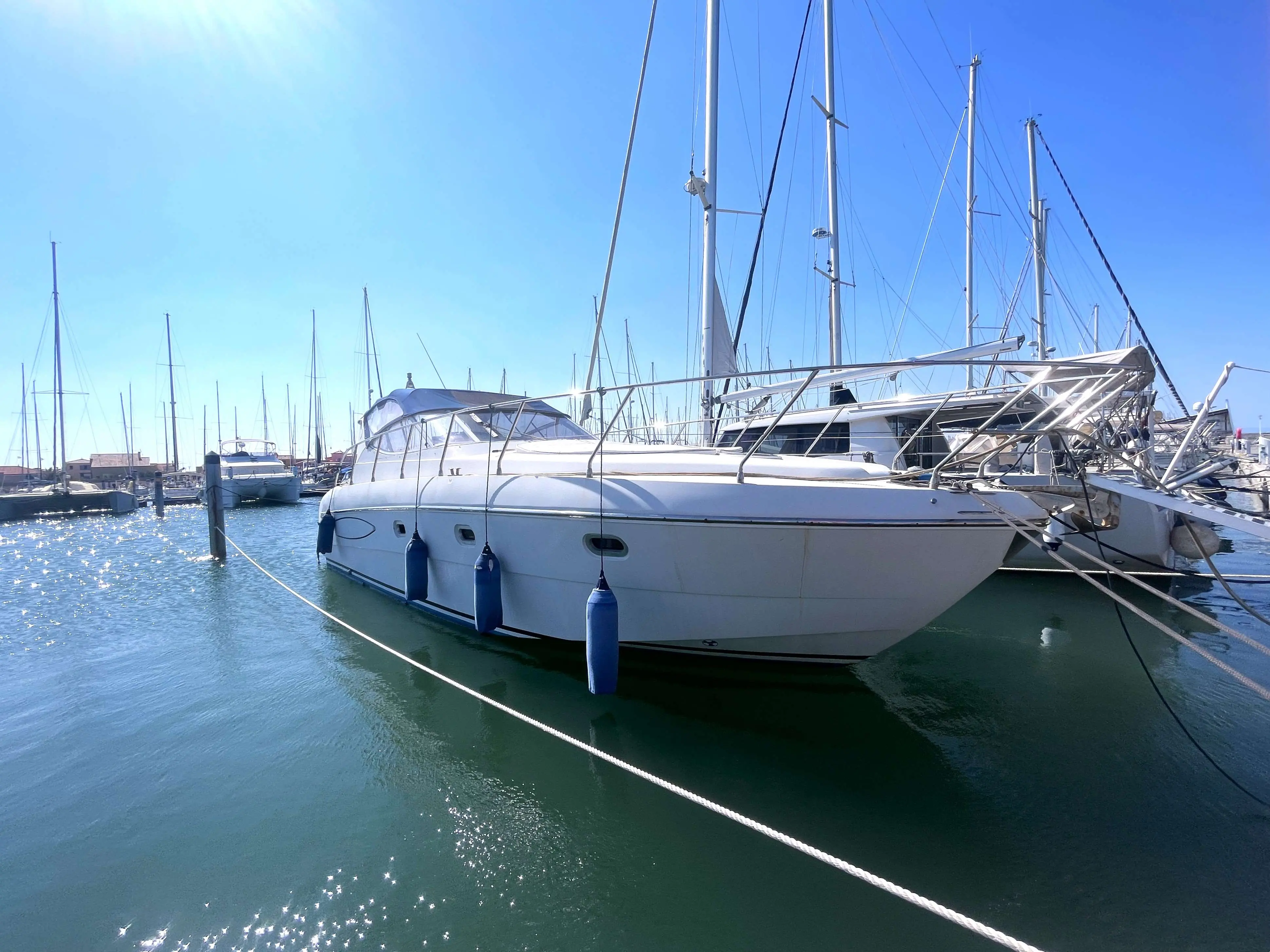 Raffaelli Shamal 40 — Bateau à moteur blanc amarré dans une marina, vu de trois quarts avant.