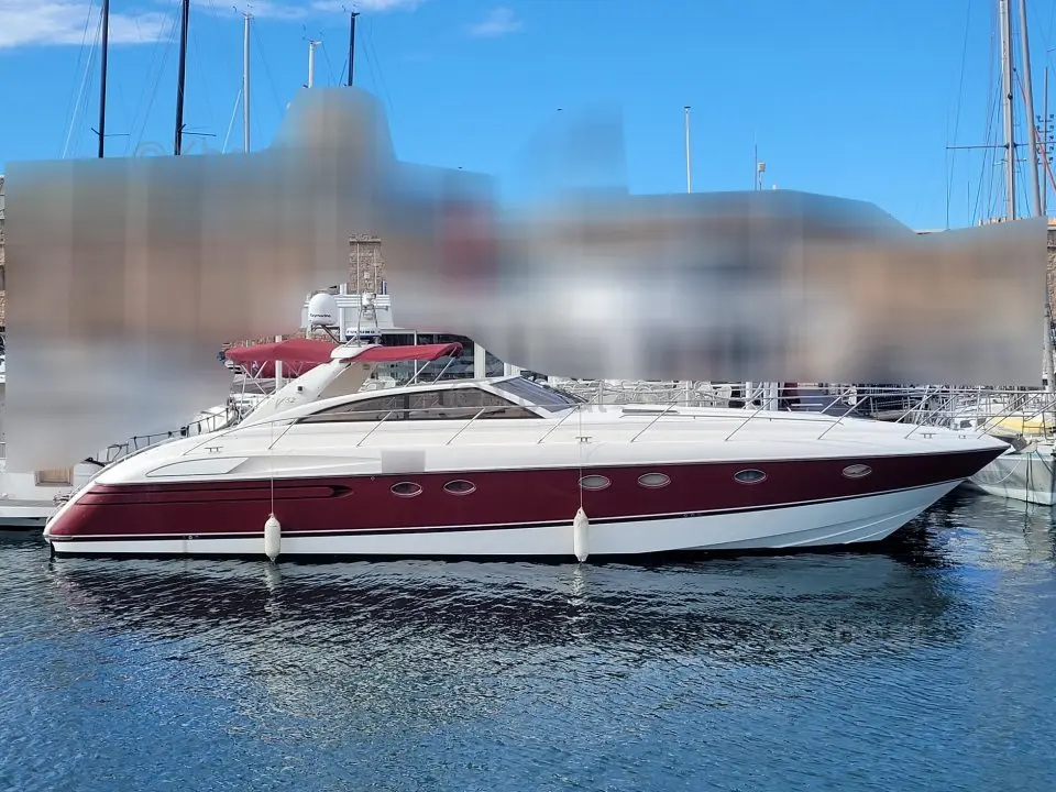 Marine Project Princess V52 — Bateau à moteur rouge et blanc amarré dans une marina, vu de profil.